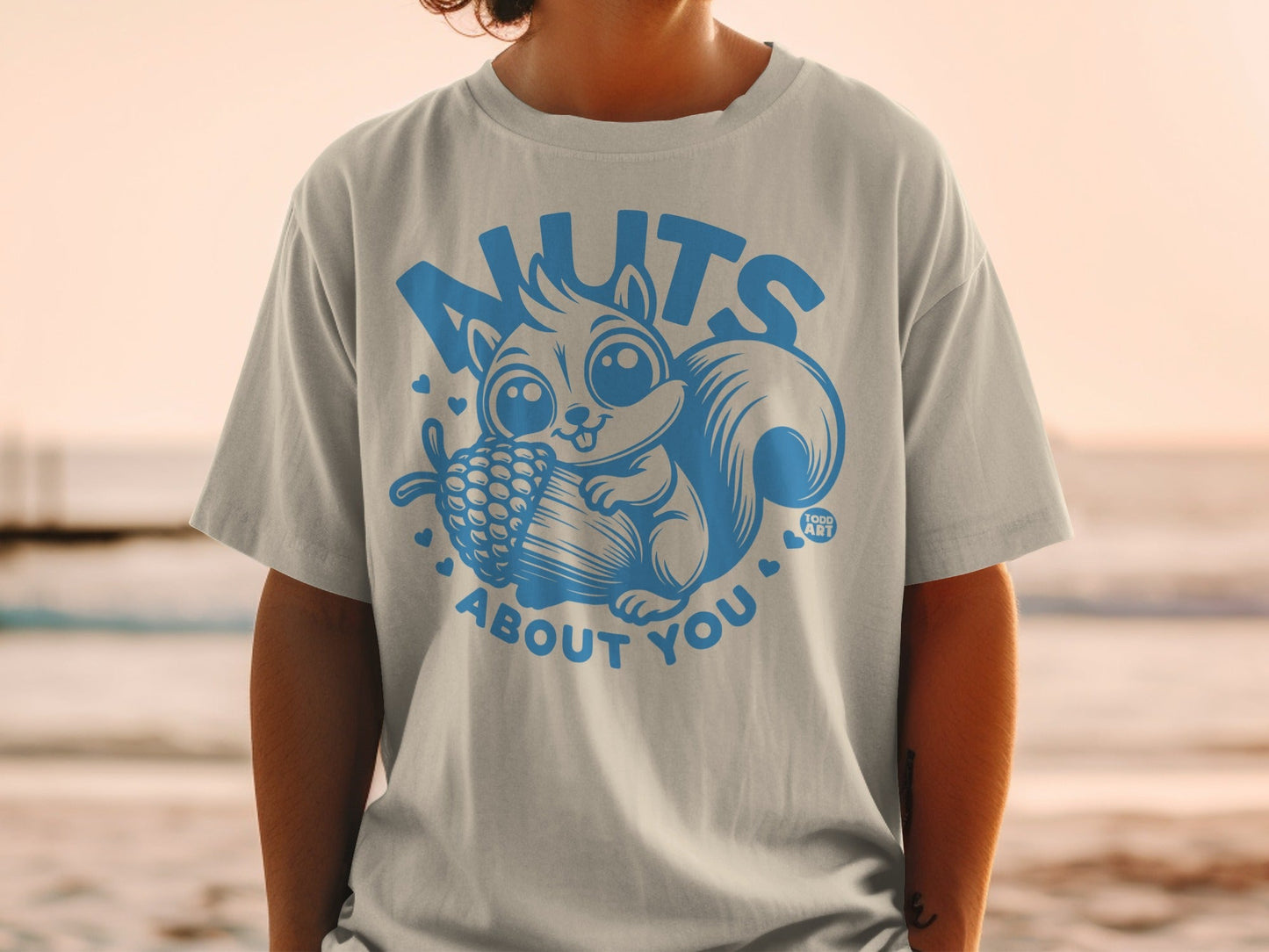 T-shirt with light blue squirrel illustration and text "Nuts About You".