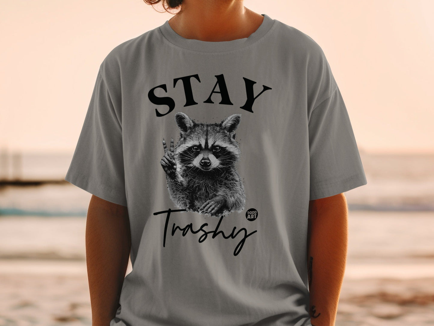 Gray t-shirt with "STAY Trashy" and raccoon graphic.