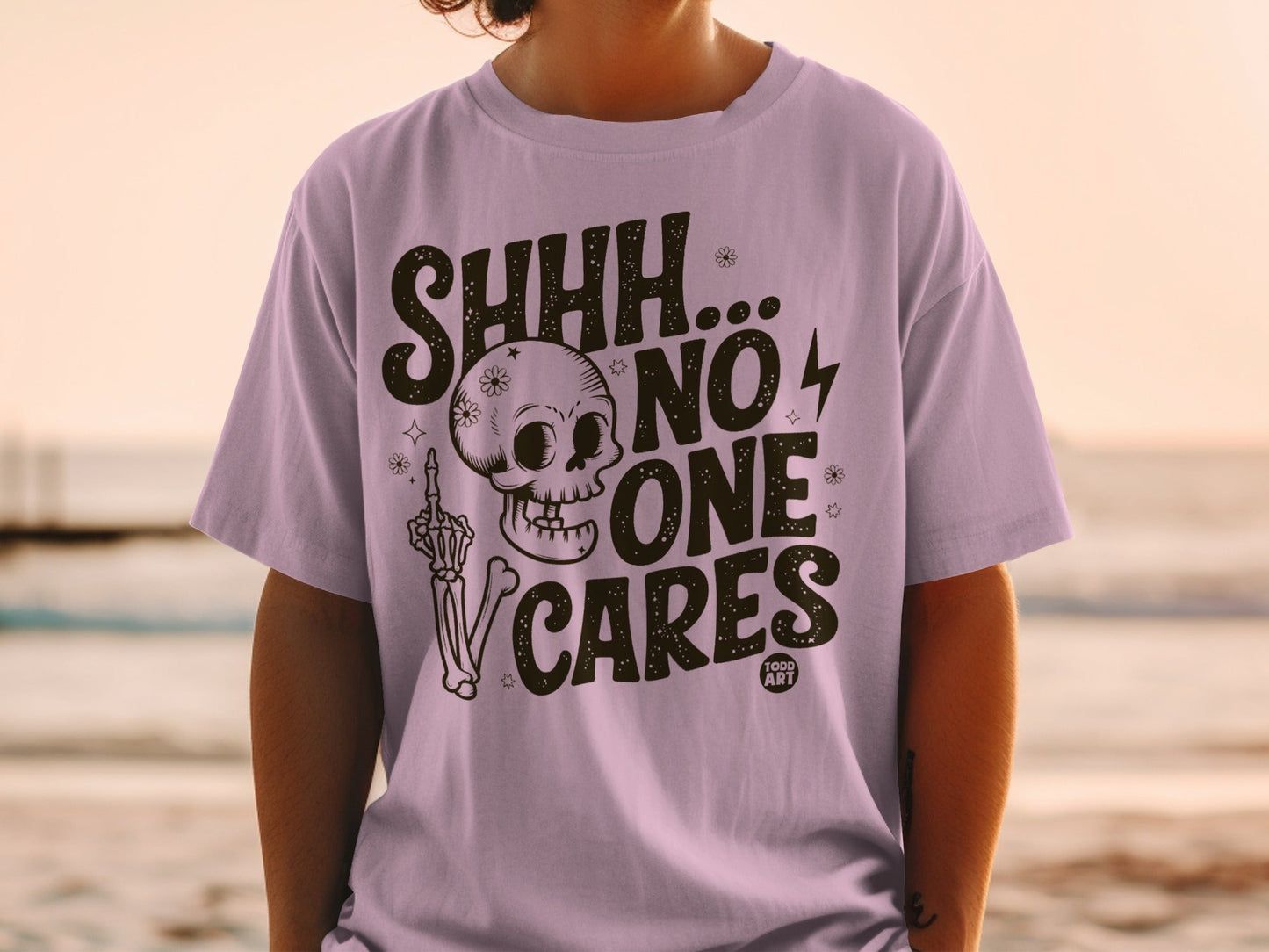 Purple t-shirt with "SHHH...NO ONE CARES" and skull graphic.