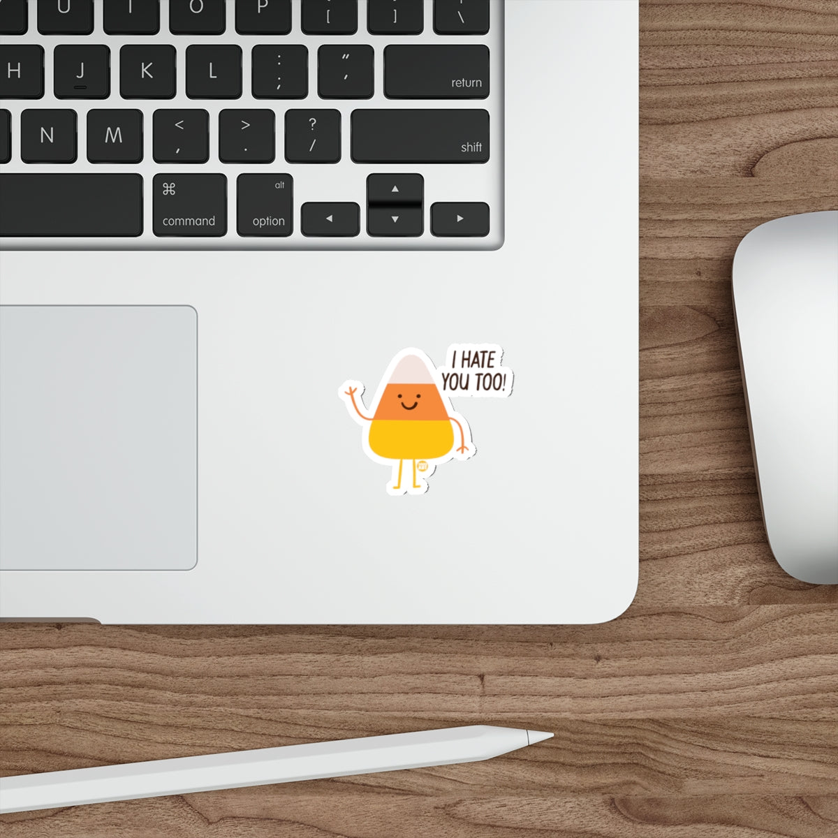 Candy corn sticker with text "I HATE YOU TOO!" on a laptop keyboard.