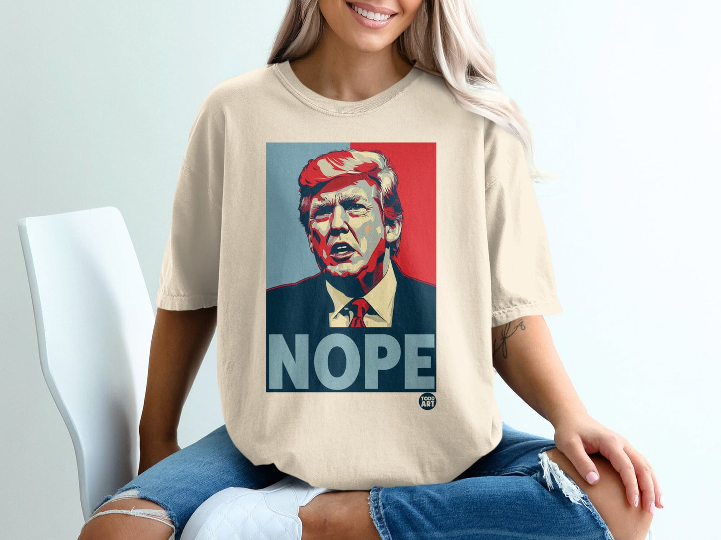 Cream t-shirt featuring a graphic of Donald Trump with "NOPE" in bold text.