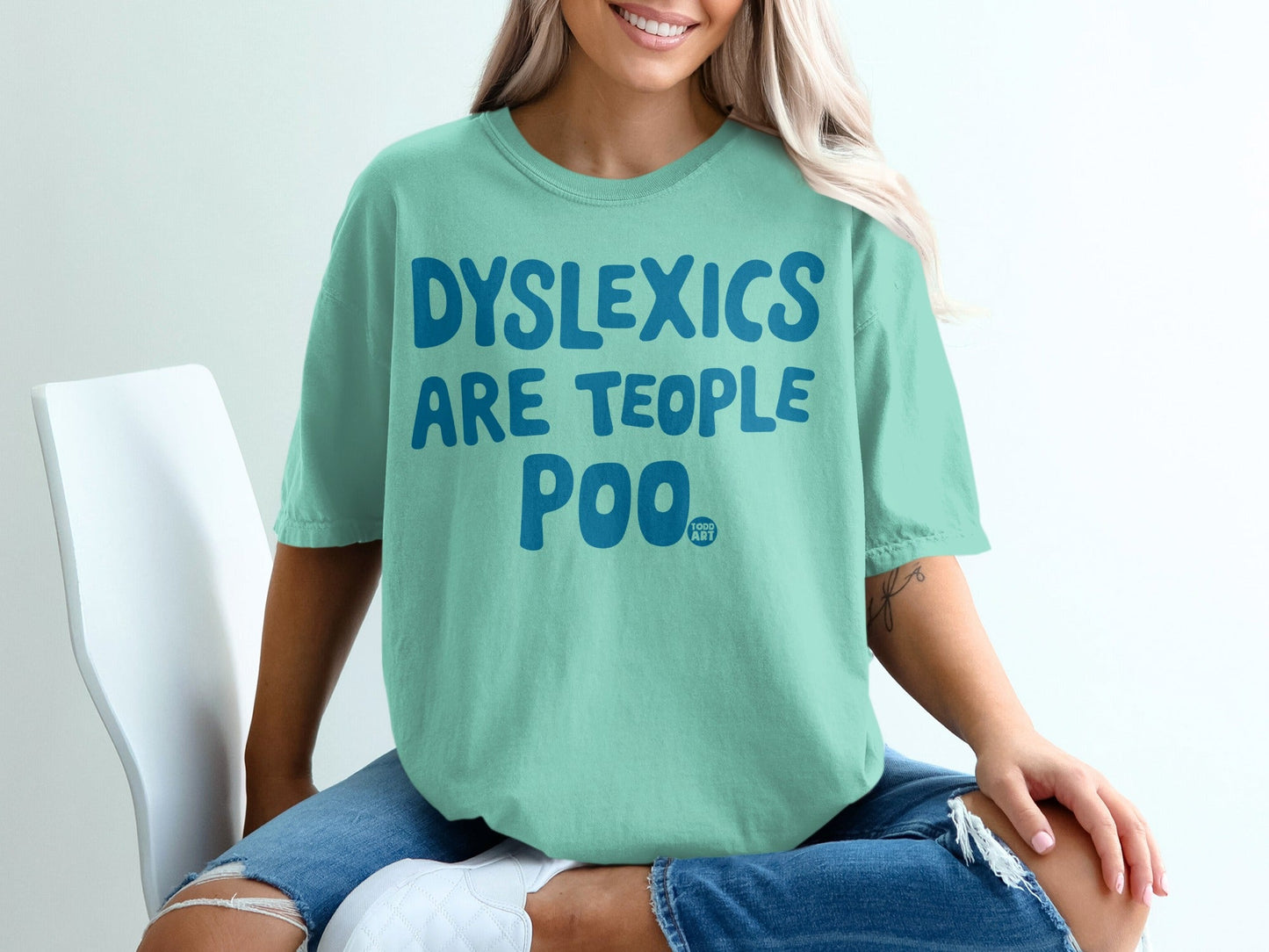 Mint green t-shirt with "DYSLEXICS ARE TEOPL POO ART" text.