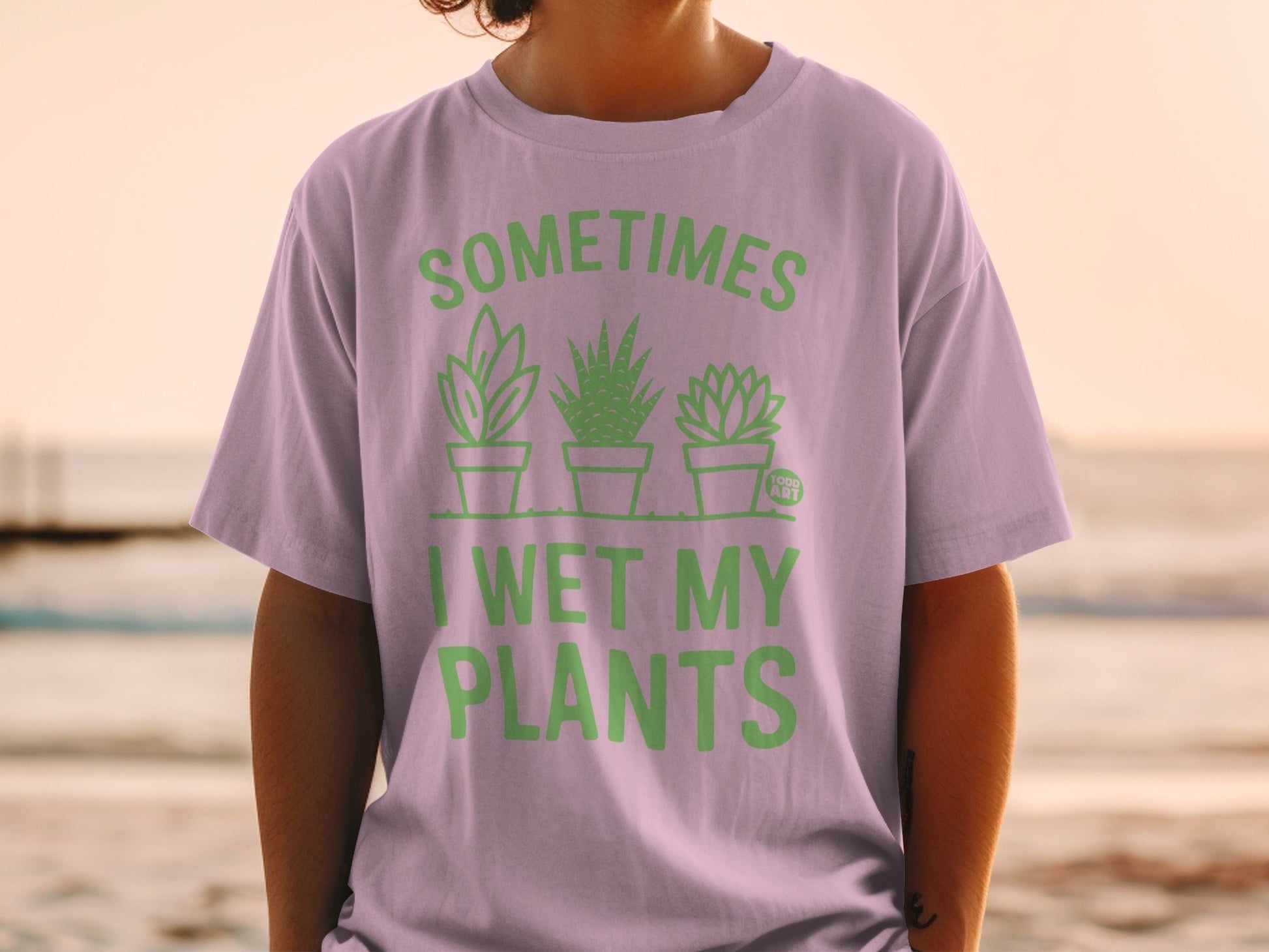 Purple t-shirt with green text and illustrations of three potted plants.