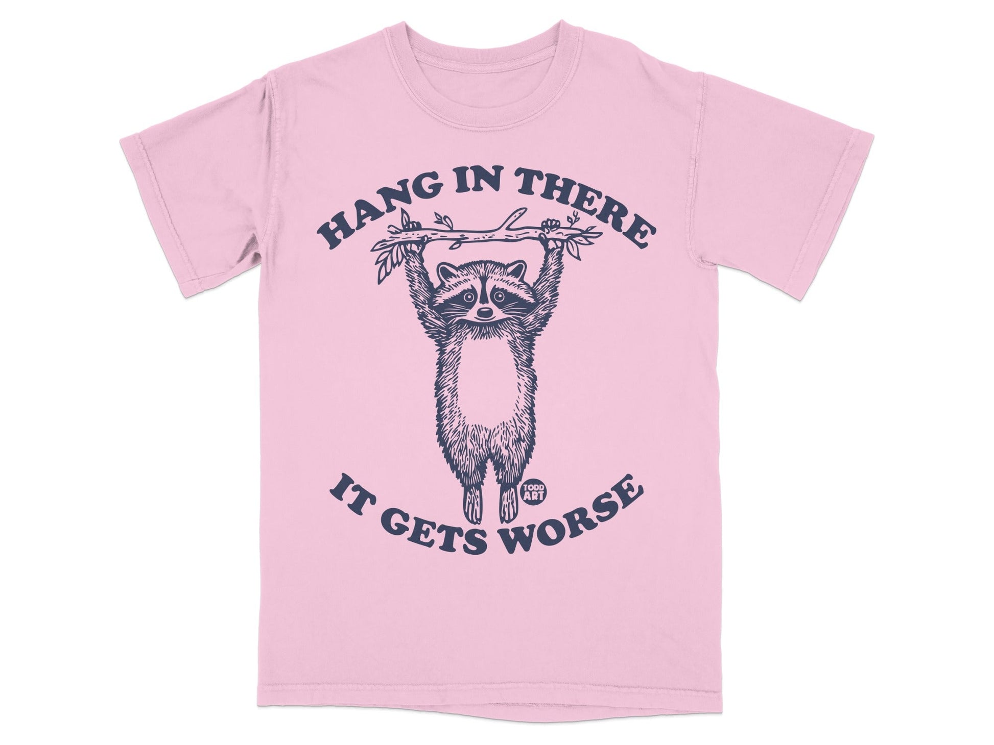 Pink t-shirt with raccoon hanging from branch, "Hang in there, it gets worse" text.