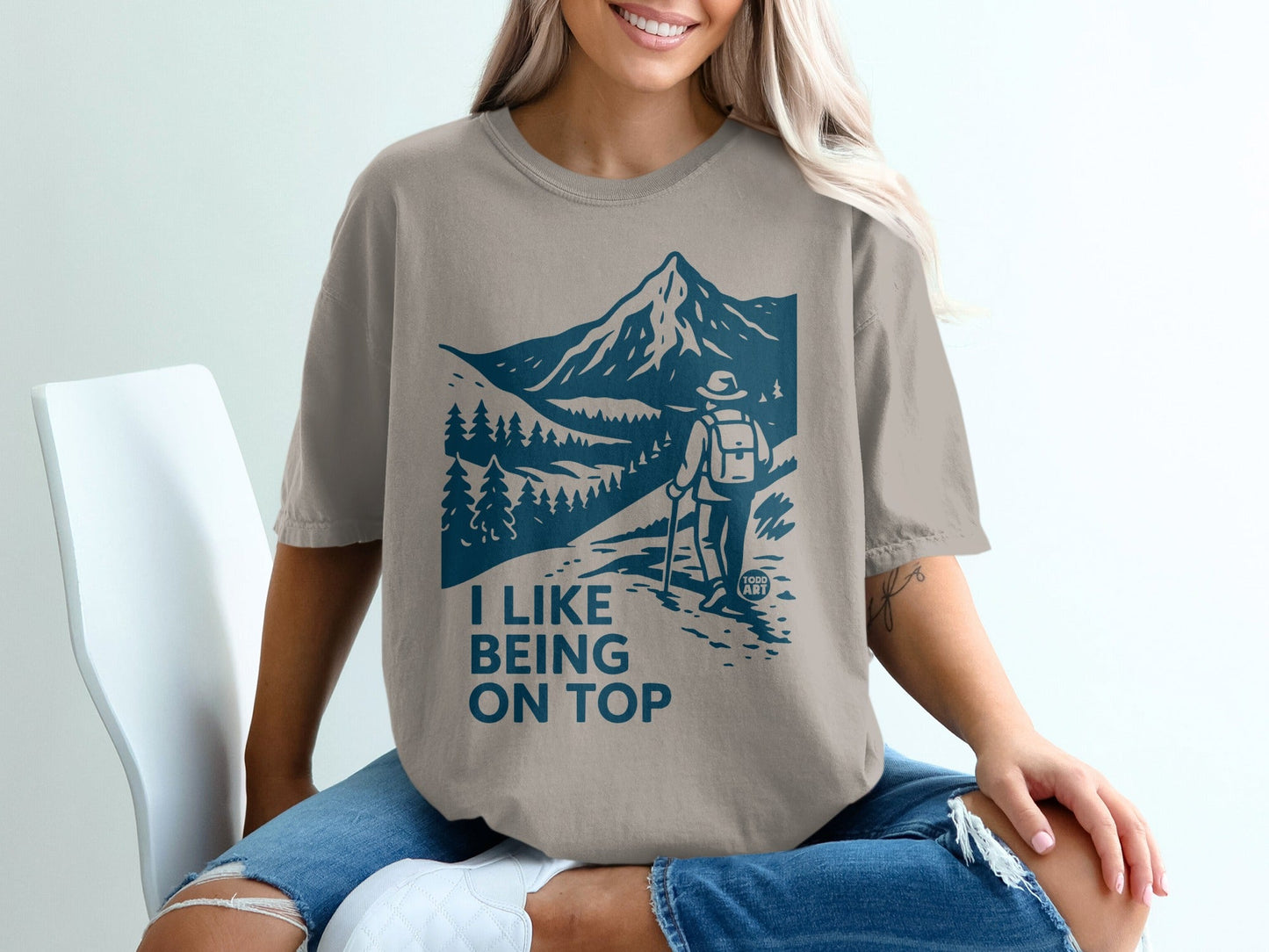T-shirt with graphic of hiker on mountain trail, "I like being on top" text.
