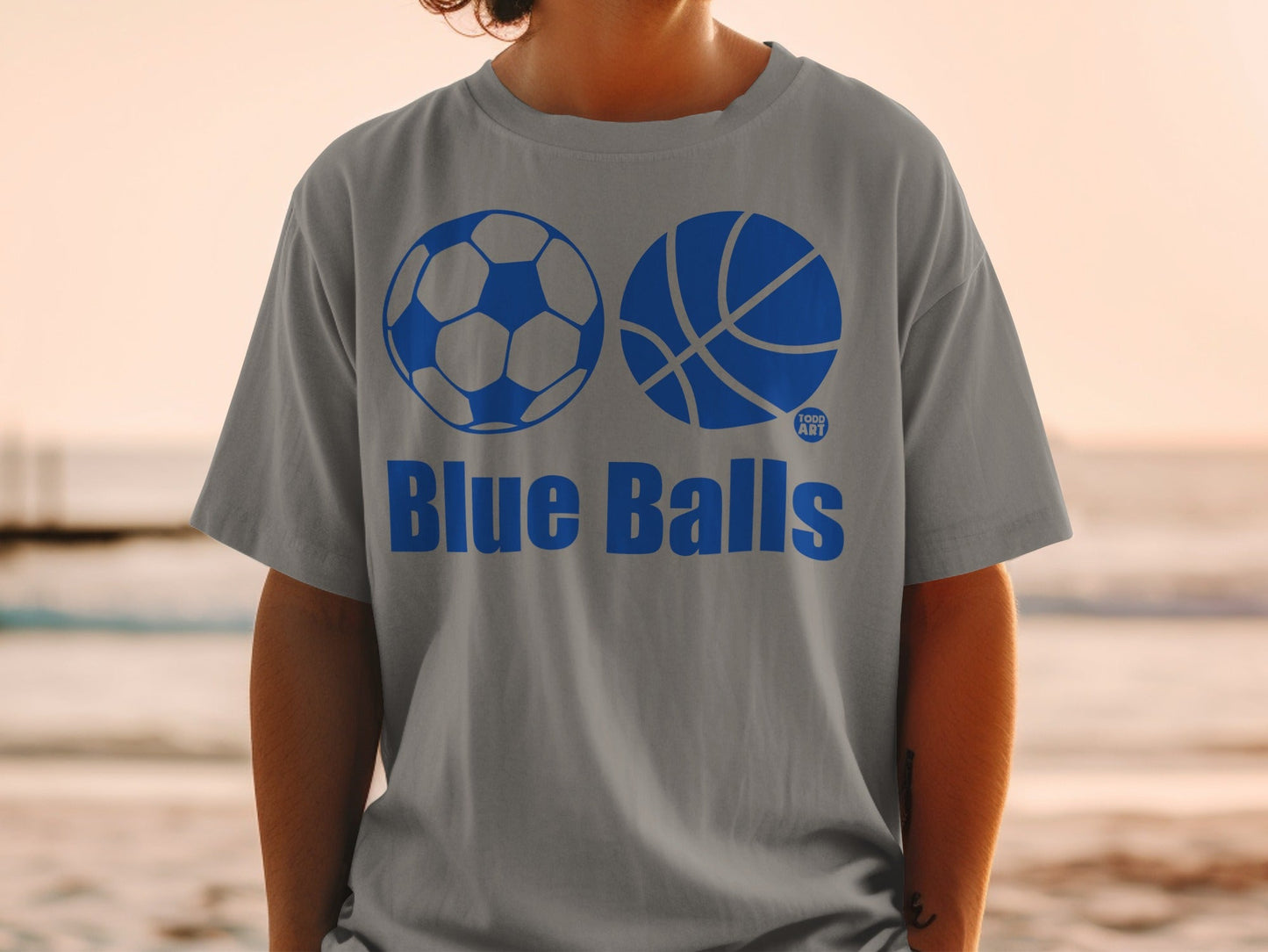 Gray t-shirt with blue soccer ball and basketball graphics and "Blue Balls" text.