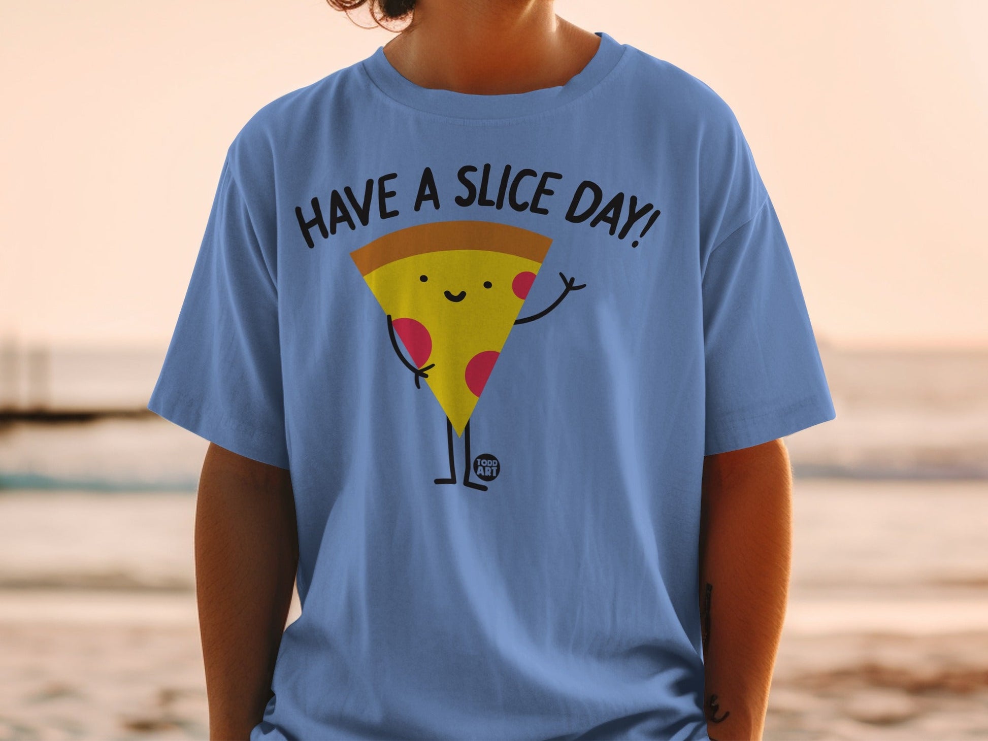 Blue t-shirt with a cartoon pizza slice saying "Have a Slice Day!".