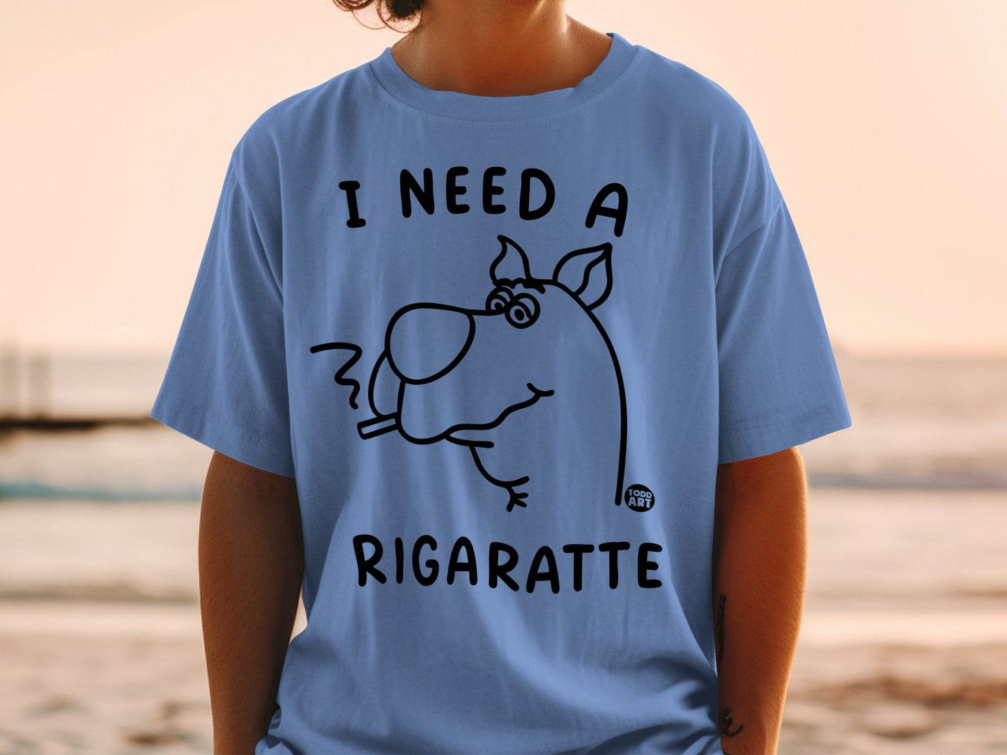 Blue t-shirt with line drawing of Scooby-Doo smoking a cigarette and text "I NEED A RIGARETTE".