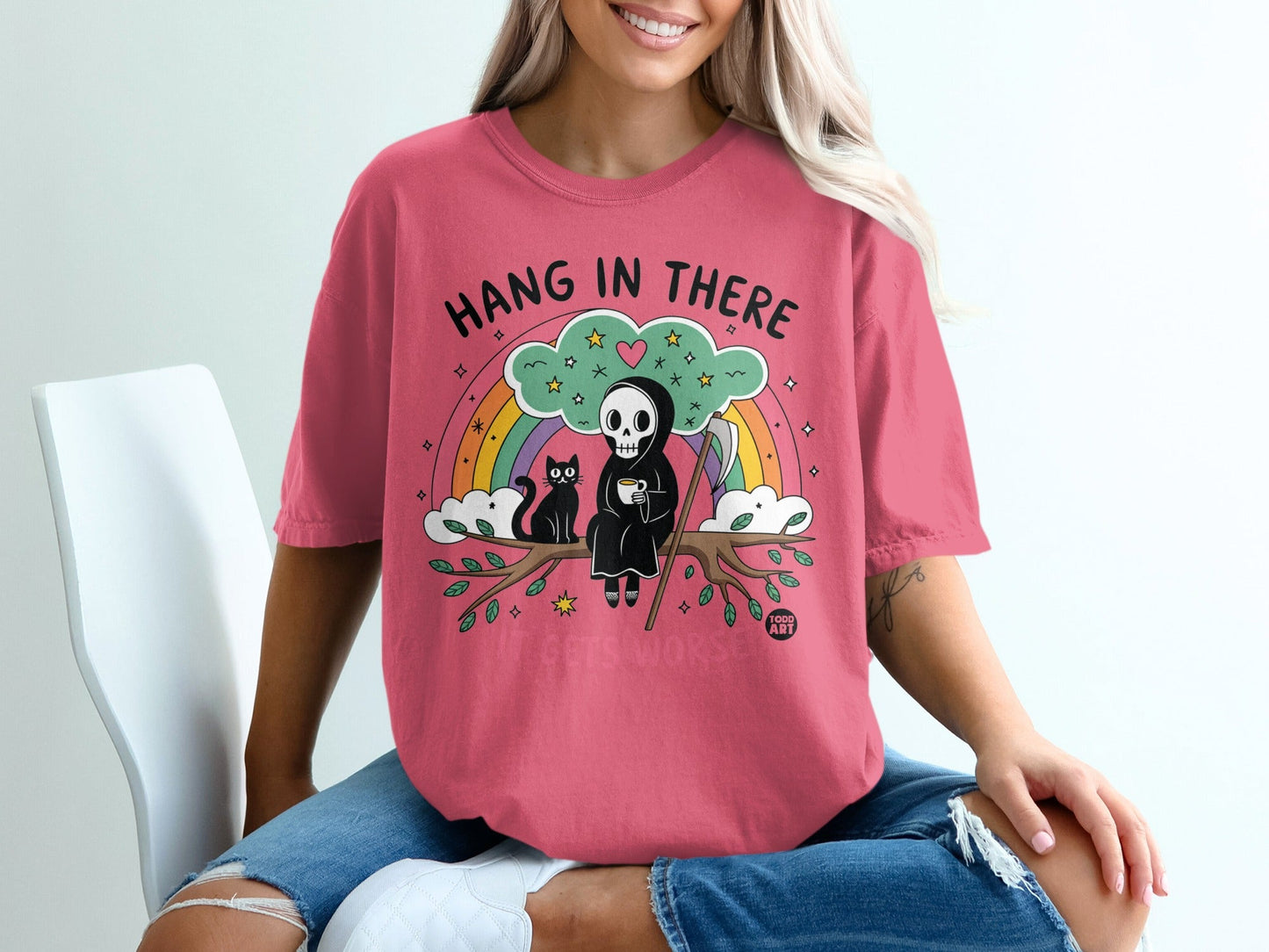 Grim reaper with cat on branch, rainbow, and clouds, text "Hang in There"
