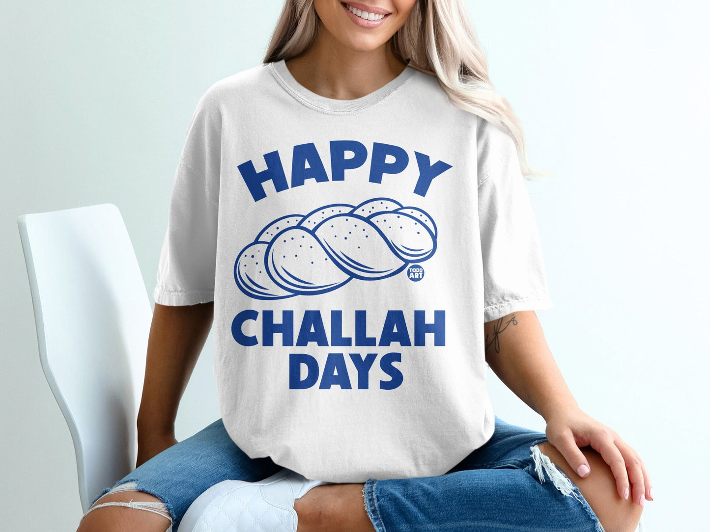 White t-shirt with "Happy Challah Days" and challah bread graphic.