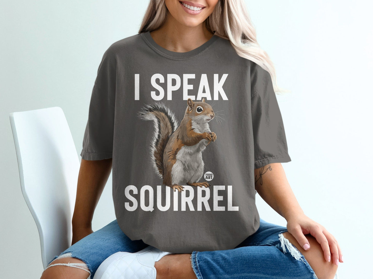 Woman wearing a dark gray t-shirt with "I SPEAK SQUIRREL" and a squirrel illustration.