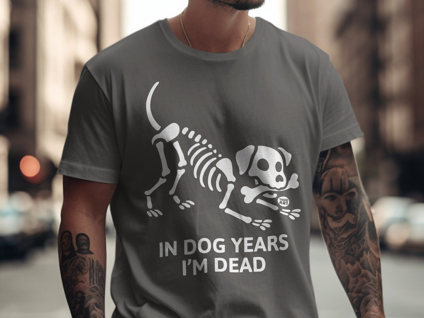 Dark grey t-shirt with white dog skeleton graphic and "IN DOG YEARS I'M DEAD" text.