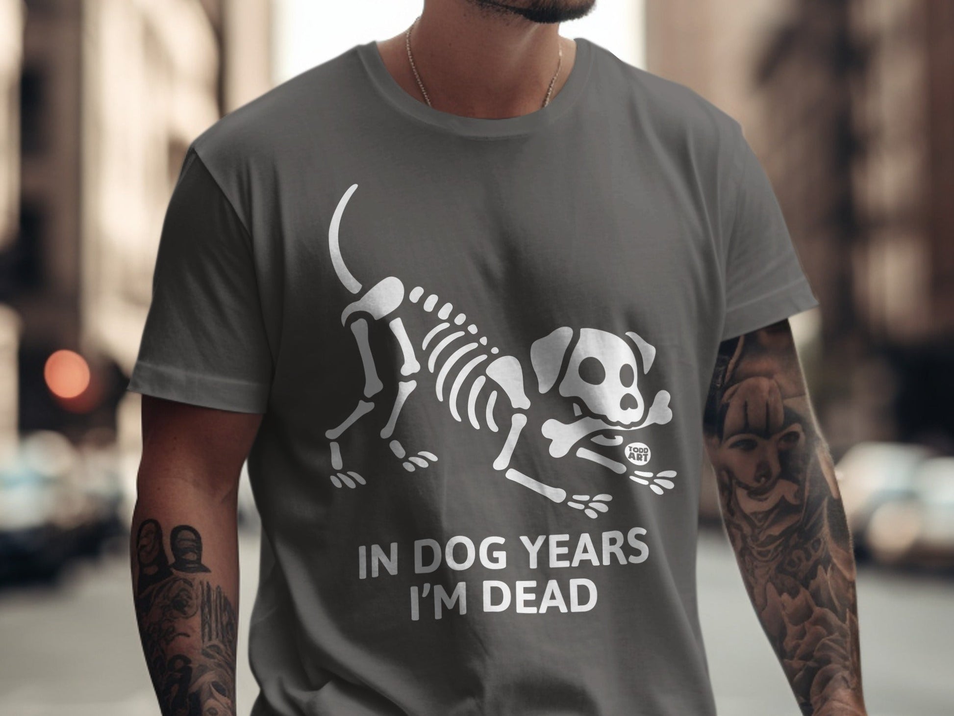 Dark grey t-shirt with white dog skeleton graphic and "IN DOG YEARS I'M DEAD" text.
