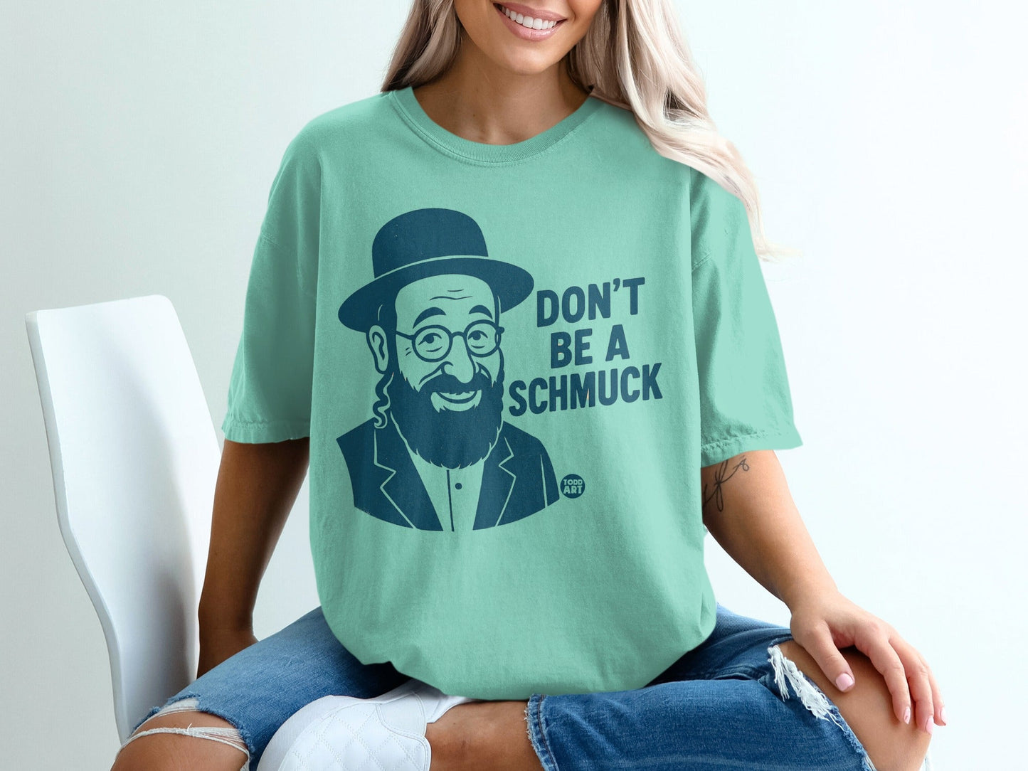 Man in hat and glasses on t-shirt, text reads "Don't Be A Schmuck".