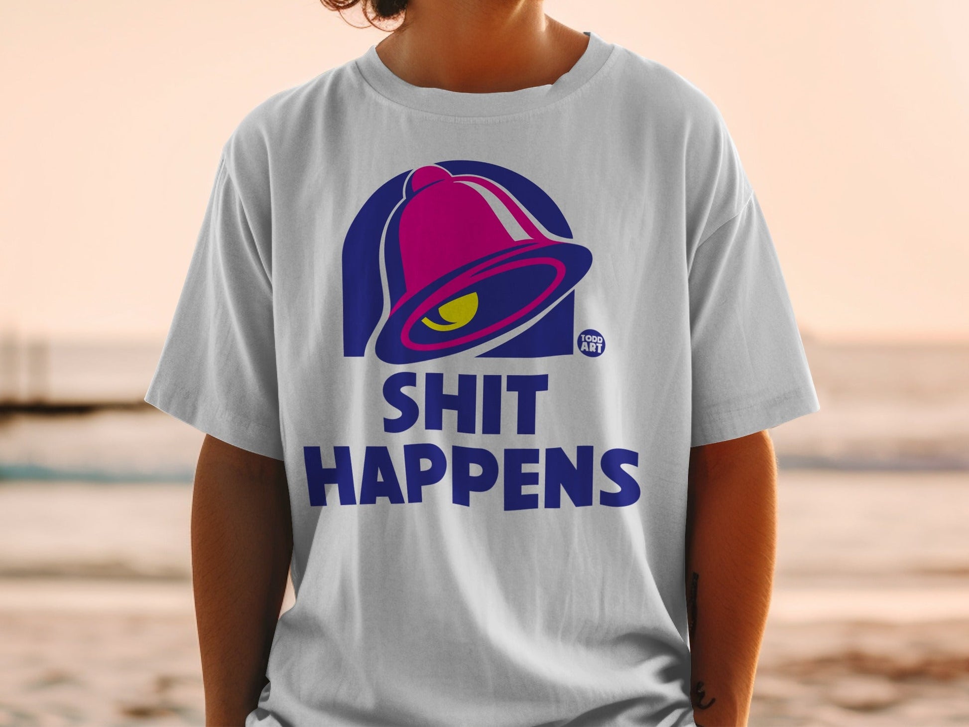 T-shirt with Taco Bell bell logo and "Shit Happens" text.