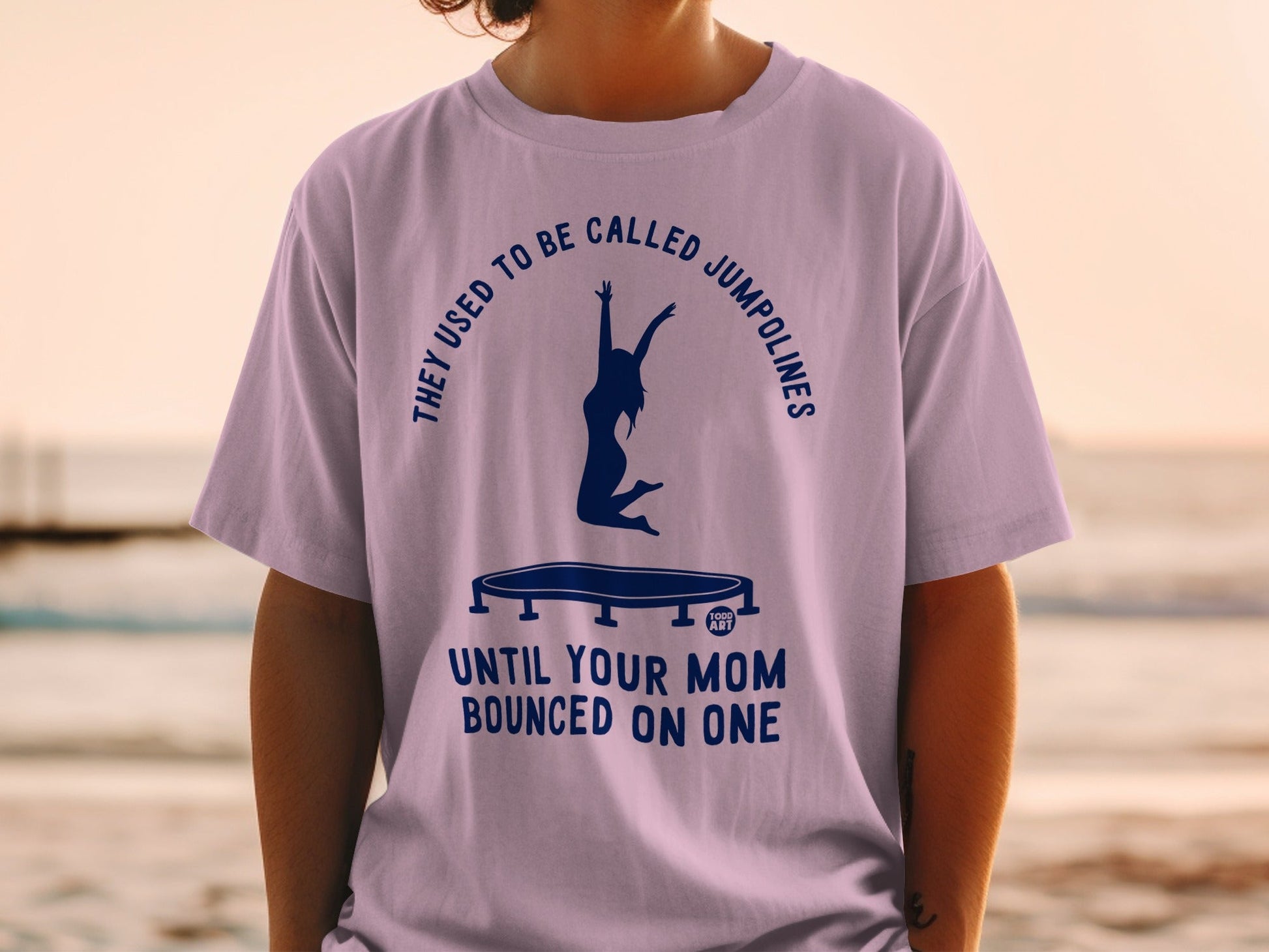 Purple t-shirt with "They used to be called jumpolines until your mom bounced on one" graphic.