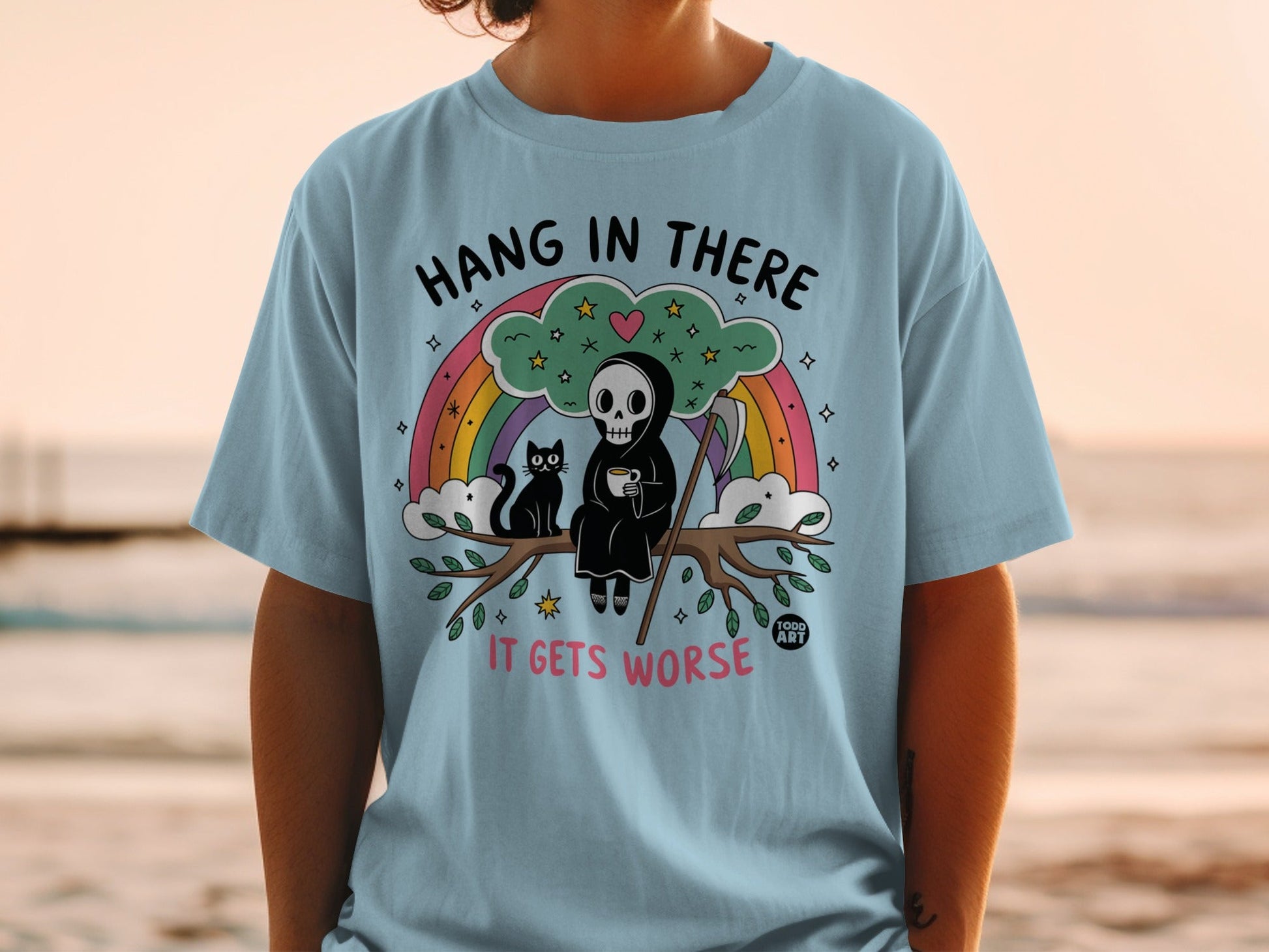 Light blue t-shirt with Grim Reaper and black cat on branch, "Hang in there it gets worse".