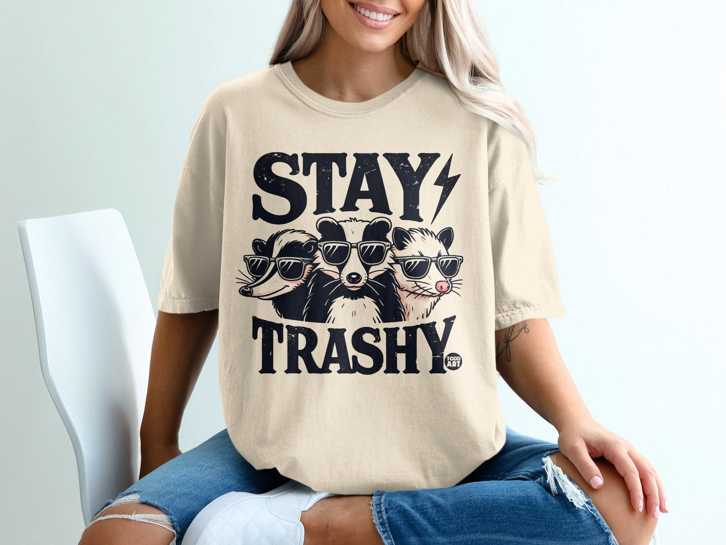 T-shirt featuring three badgers in sunglasses with "STAY TRASHY" text.