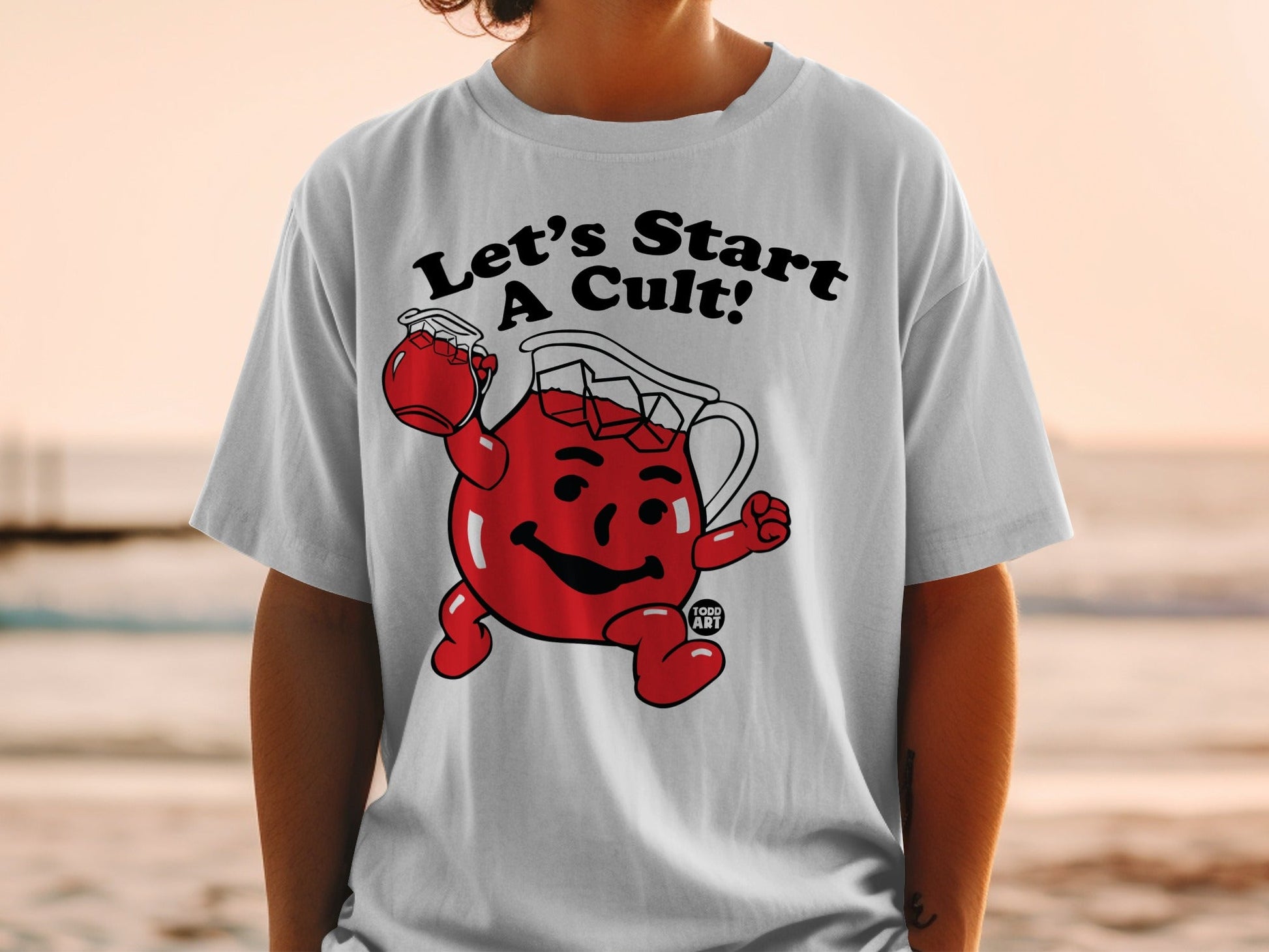 White t-shirt with Kool-Aid Man character and "Let's Start A Cult!" text.