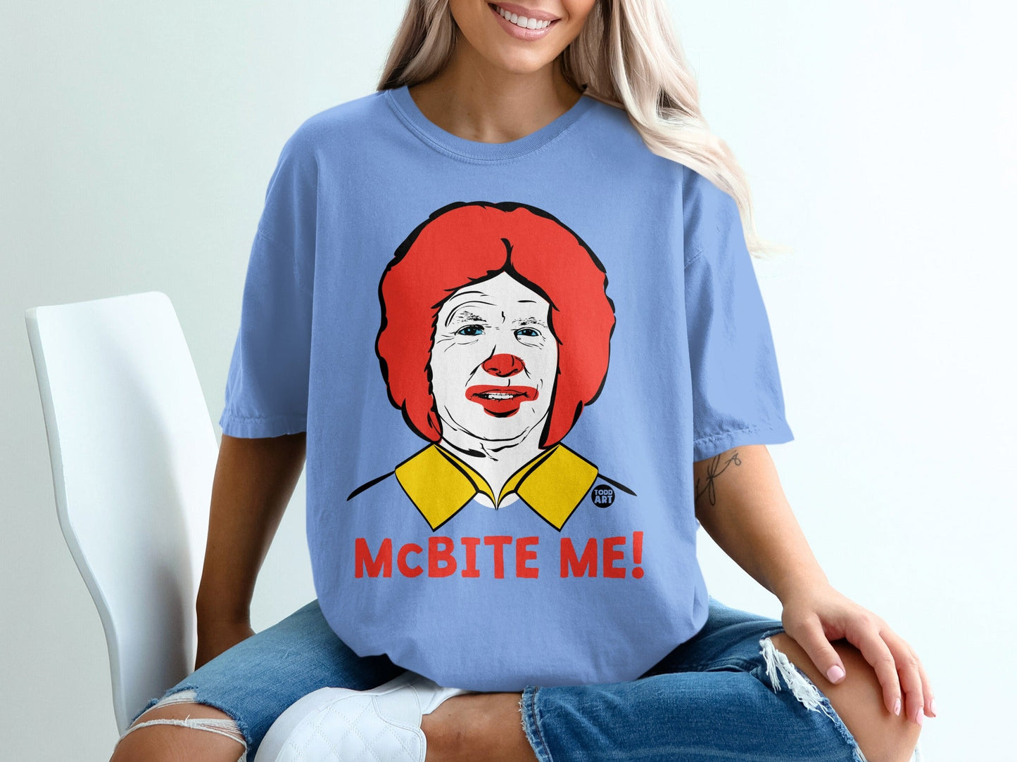 Blue t-shirt with cartoon Ronald McDonald and text "McBITE ME!".