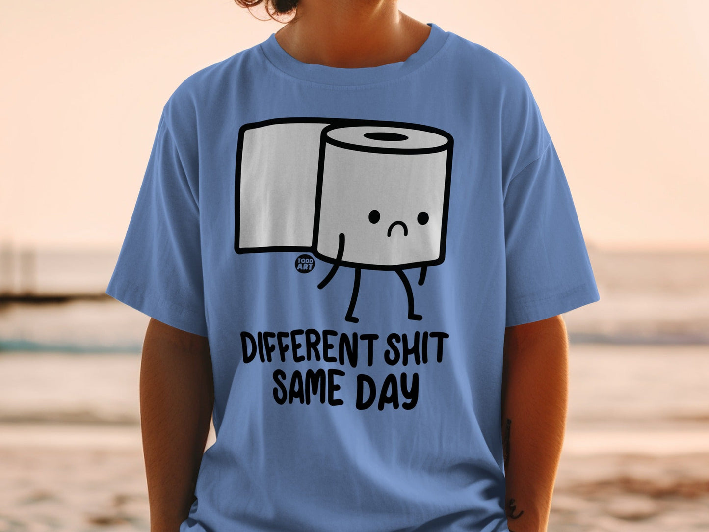 T-shirt with cartoon toilet paper roll and text "DIFFERENT SHIT SAME DAY."