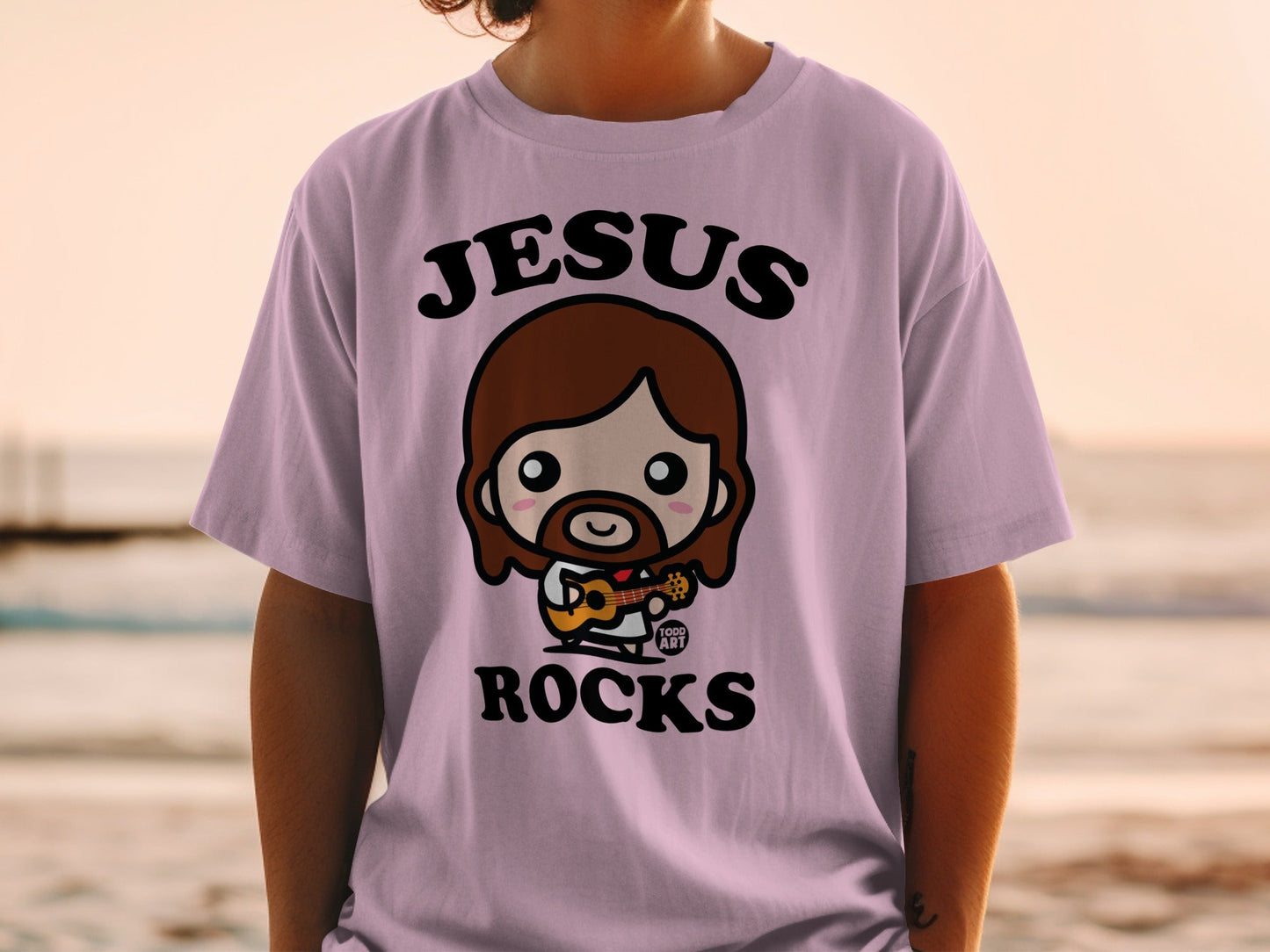 Chibi Jesus character playing guitar on a t-shirt.