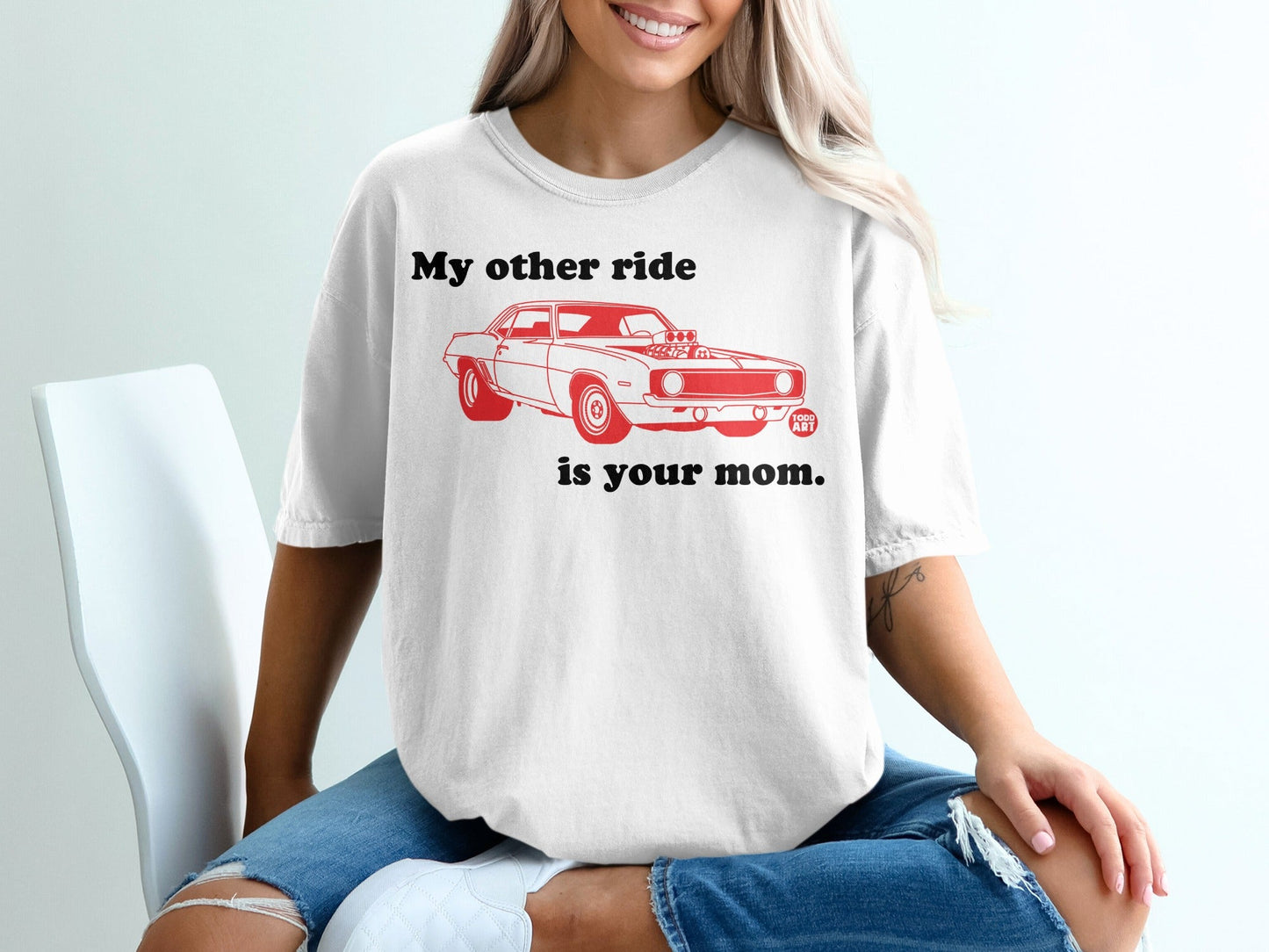 White t-shirt with red graphic of a car and text "My other ride is your mom."