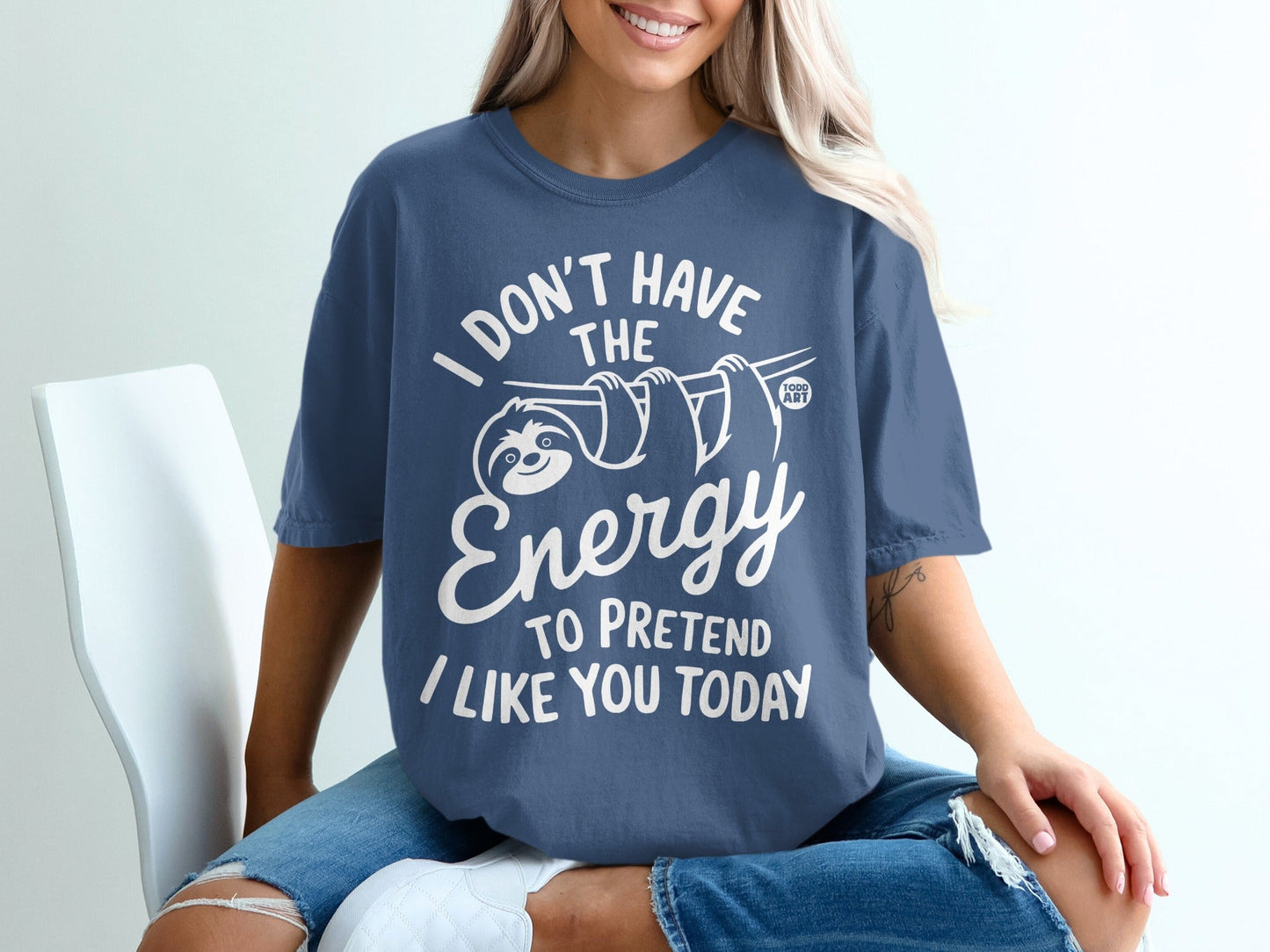 Blue t-shirt with white text and sloth graphic: "I don't have the energy to pretend I like you today".