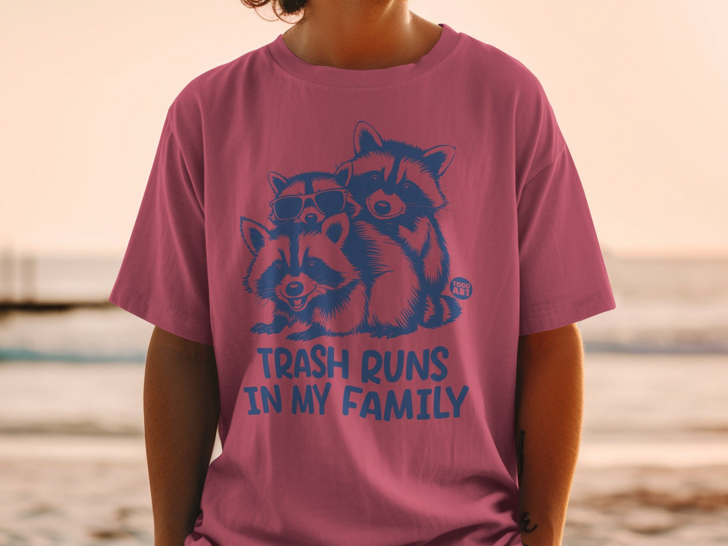 T-shirt with three raccoons, two wearing sunglasses, and text "TRASH RUNS IN MY FAMILY".