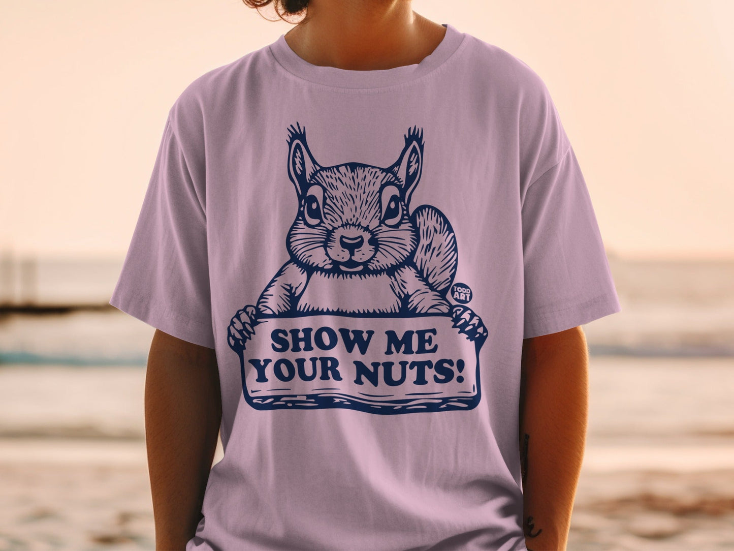 T-shirt with a squirrel holding a sign that says "SHOW ME YOUR NUTS!".