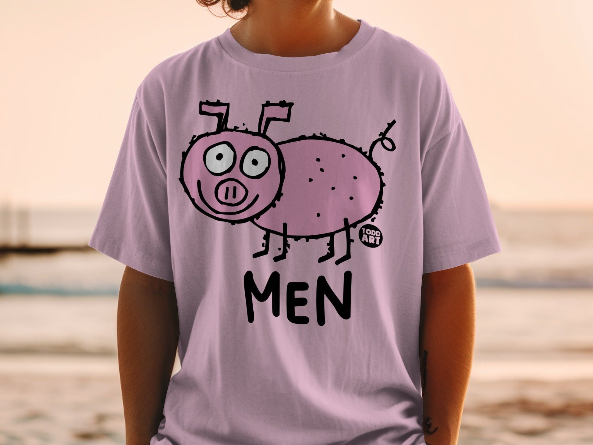 Pink t-shirt with a cartoon pig and "MEN" text on a person.