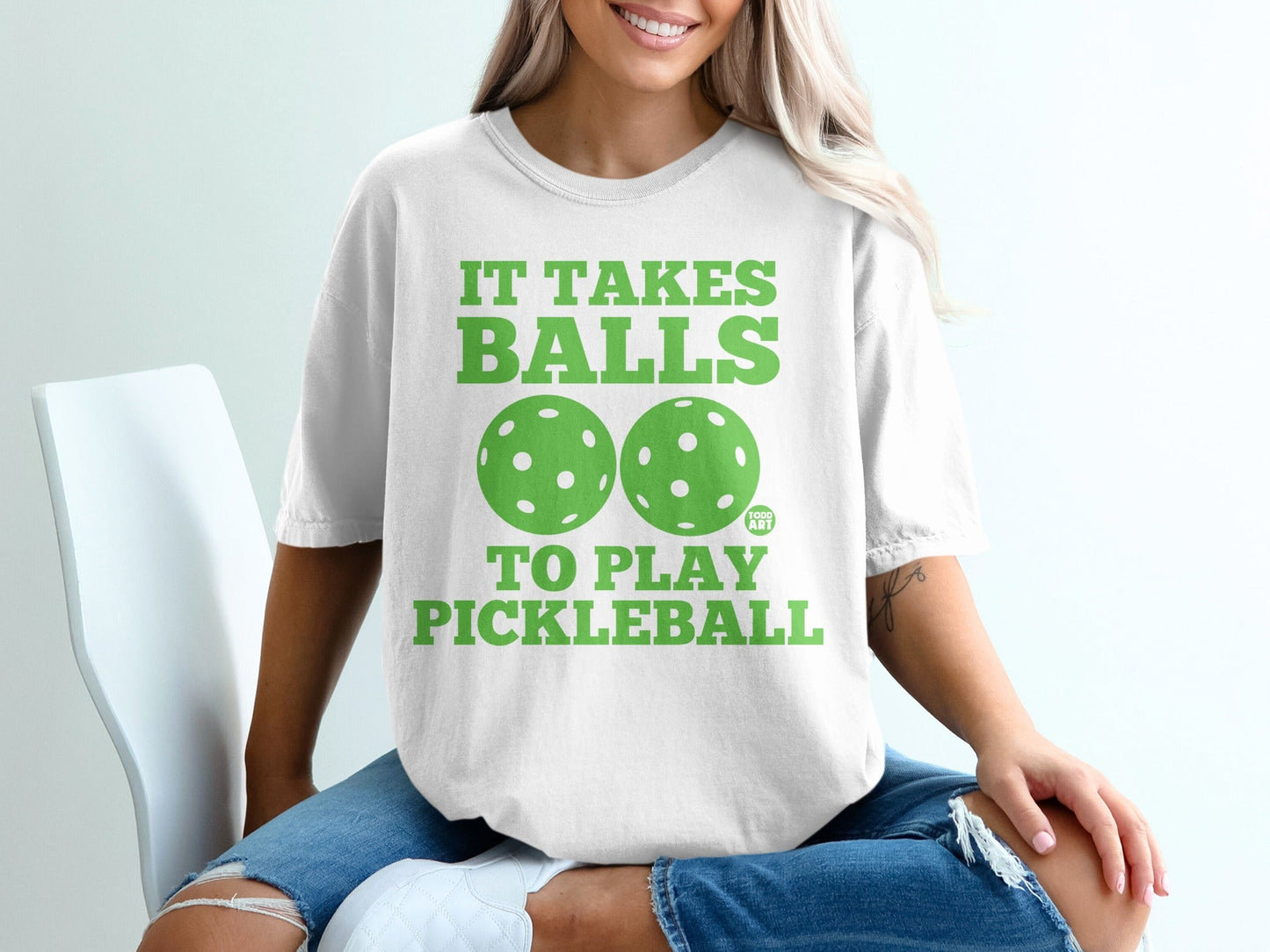 White t-shirt with green text "IT TAKES BALLS TO PLAY PICKLEBALL" and two pickleballs.