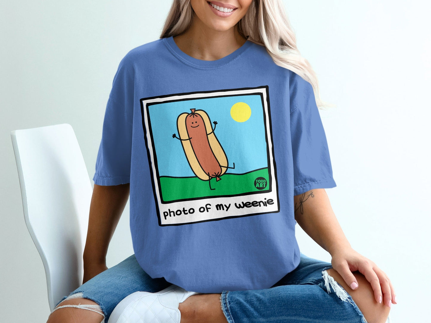 Cartoon hot dog with arms raised in grass under a sun, text "photo of my weenie".