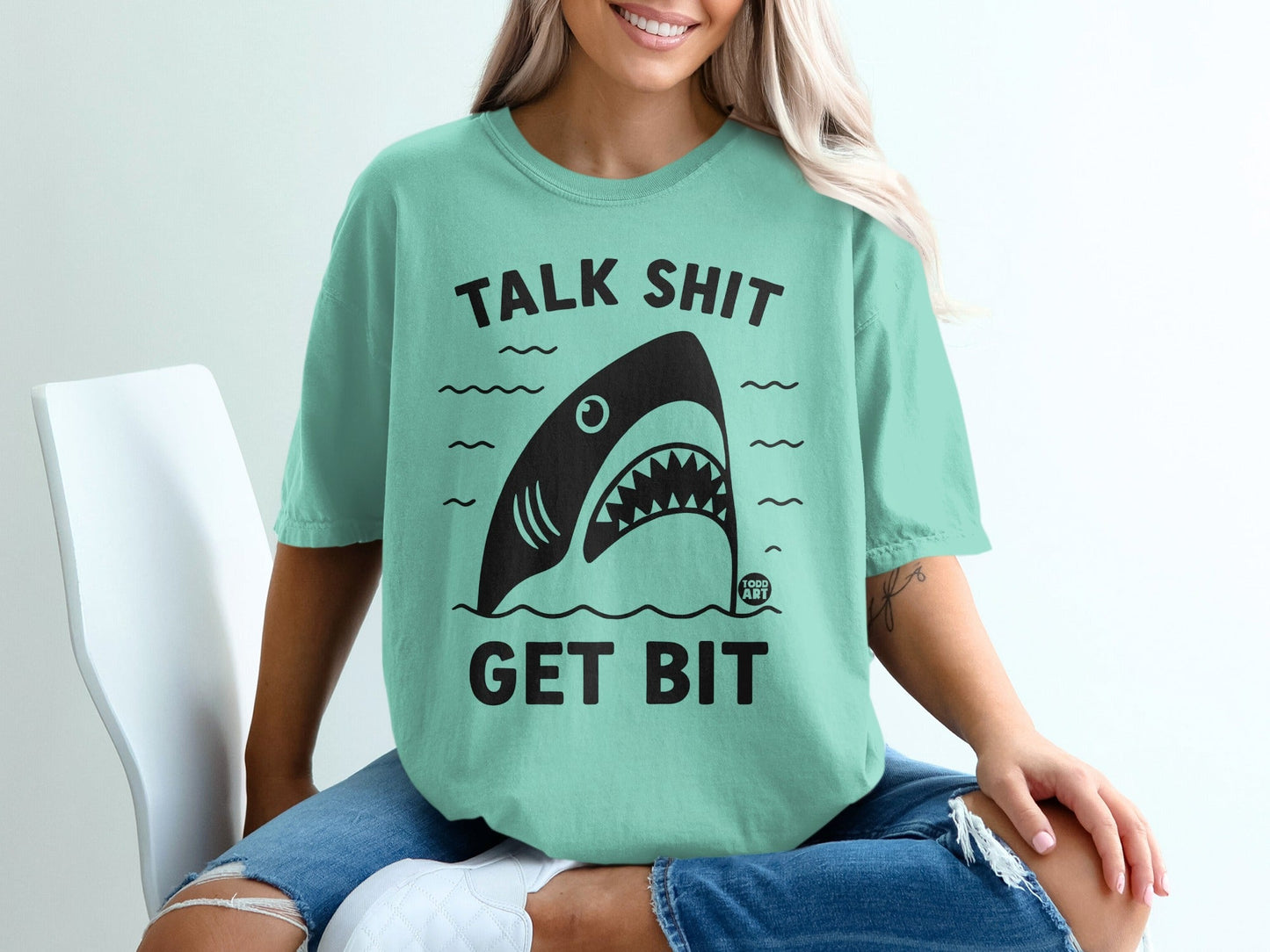 Mint green t-shirt with shark graphic and text "TALK SHIT GET BIT".