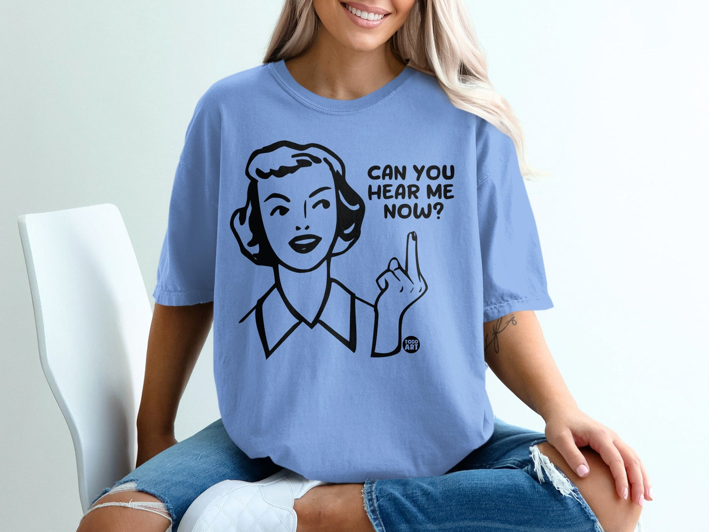 Light blue t-shirt with "Can you hear me now?" graphic and a woman pointing.