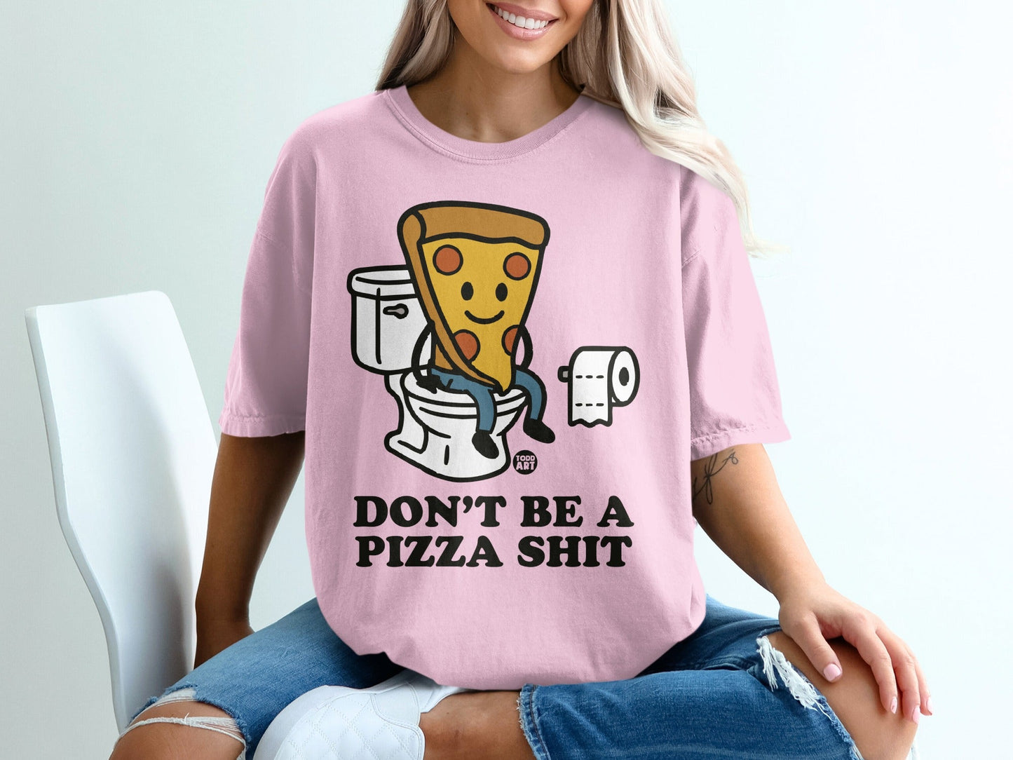 Pink t-shirt with cartoon pizza on toilet and text "Don't Be a Pizza Shit".
