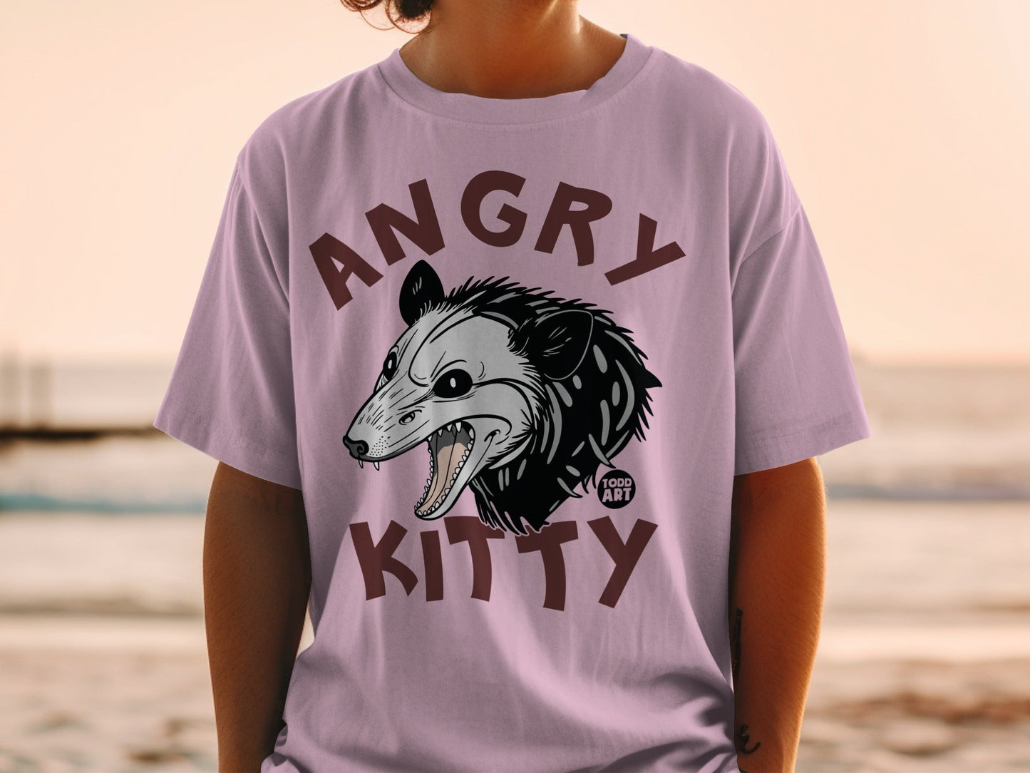 Purple t-shirt with an angry opossum graphic and "ANGRY KITTY TOOD ART" text.