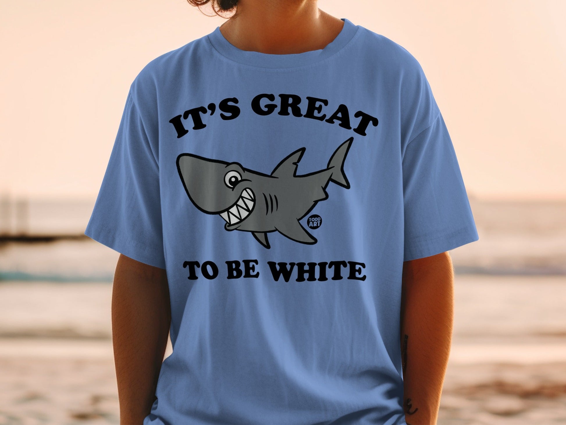 Blue t-shirt with cartoon shark graphic and text "IT'S GREAT TO BE WHITE".