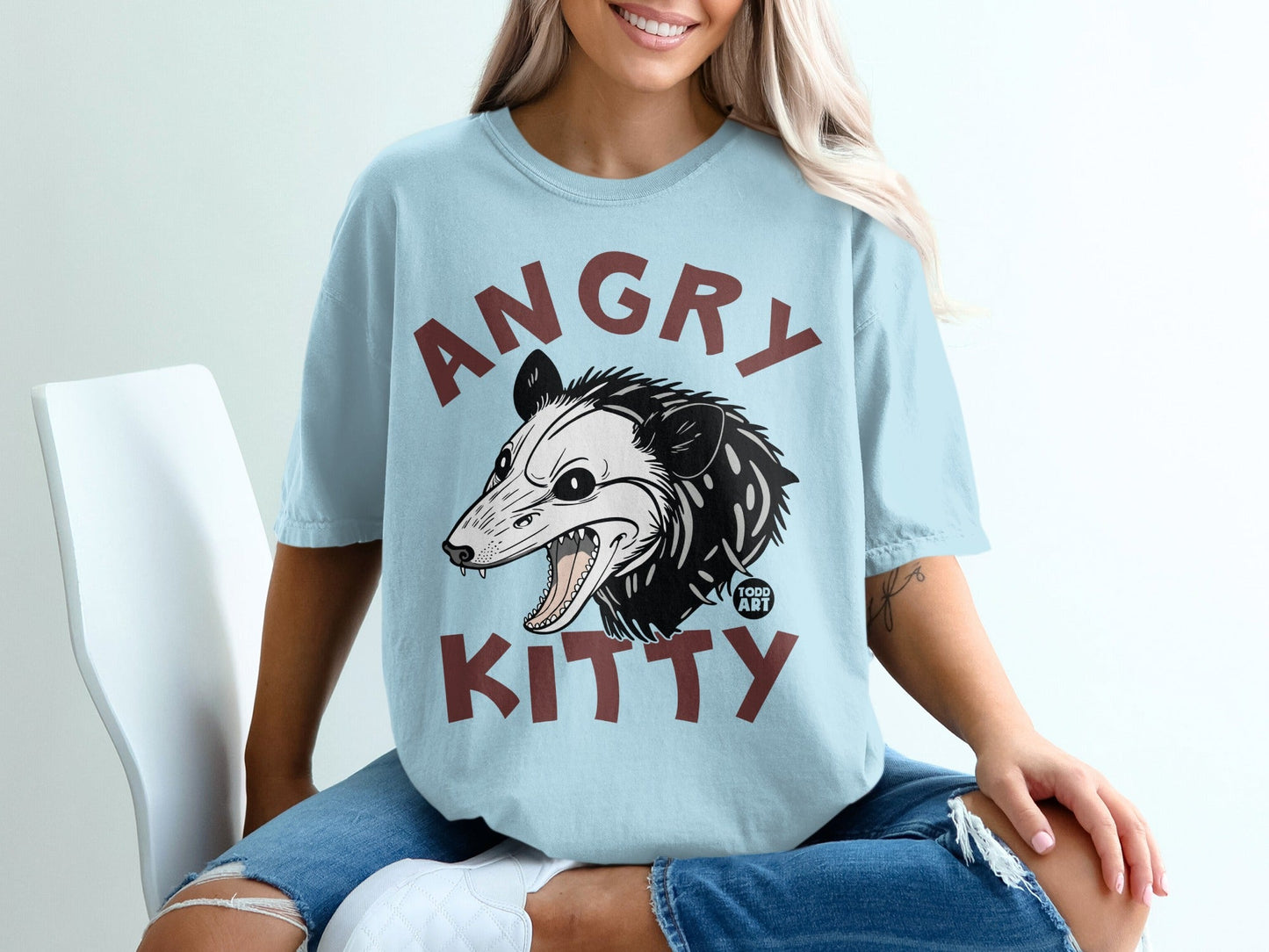 Light blue t-shirt with an angry possum illustration and "ANGRY KITTY" text.