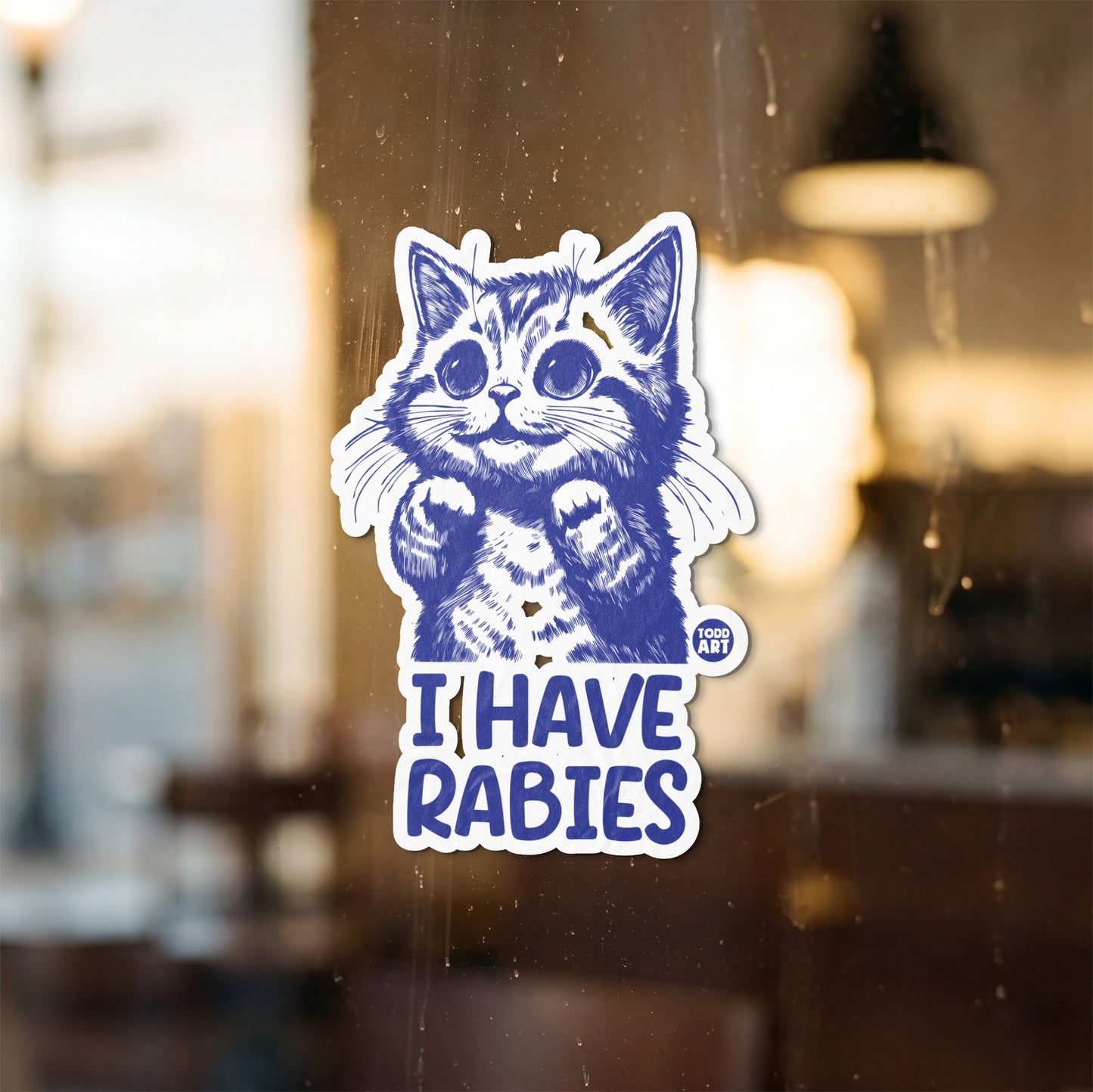 Blue illustration of a kitten with large eyes and paws raised, reads "I HAVE RABIES".