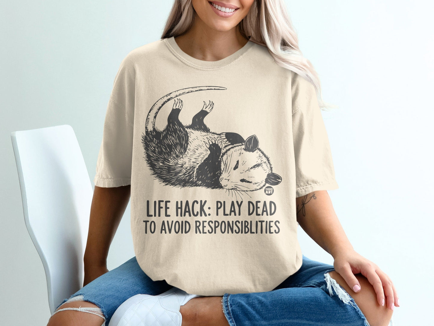 Opossum graphic tee with text "LIFE HACK: PLAY DEAD TO AVOID RESPONSIBILITIES".