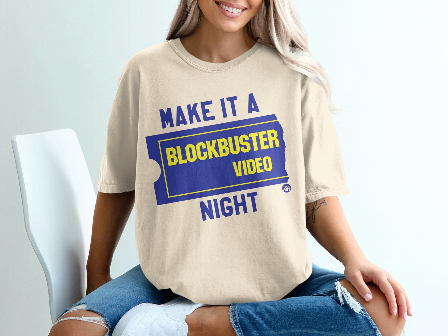 Cream t-shirt with "Make it a Blockbuster Night" text and film ticket graphic.