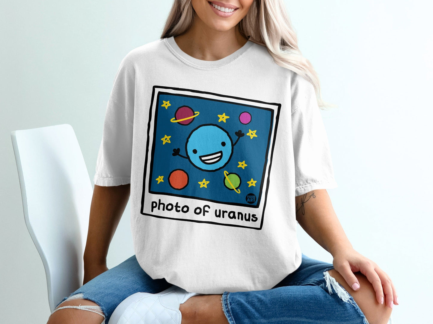 Cartoon blue planet with stars and planets on a white t-shirt.