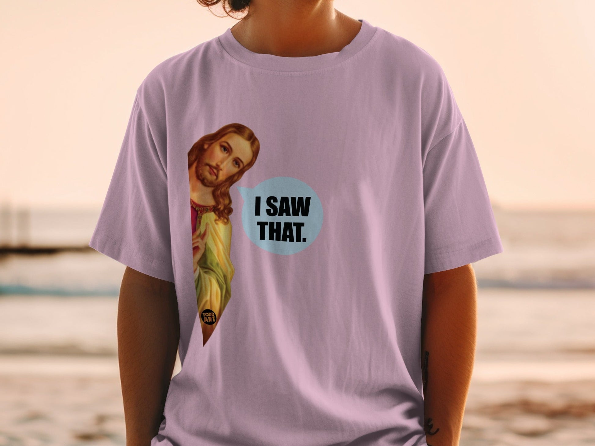 Jesus peeks out from a purple t-shirt, speech bubble says "I SAW THAT."