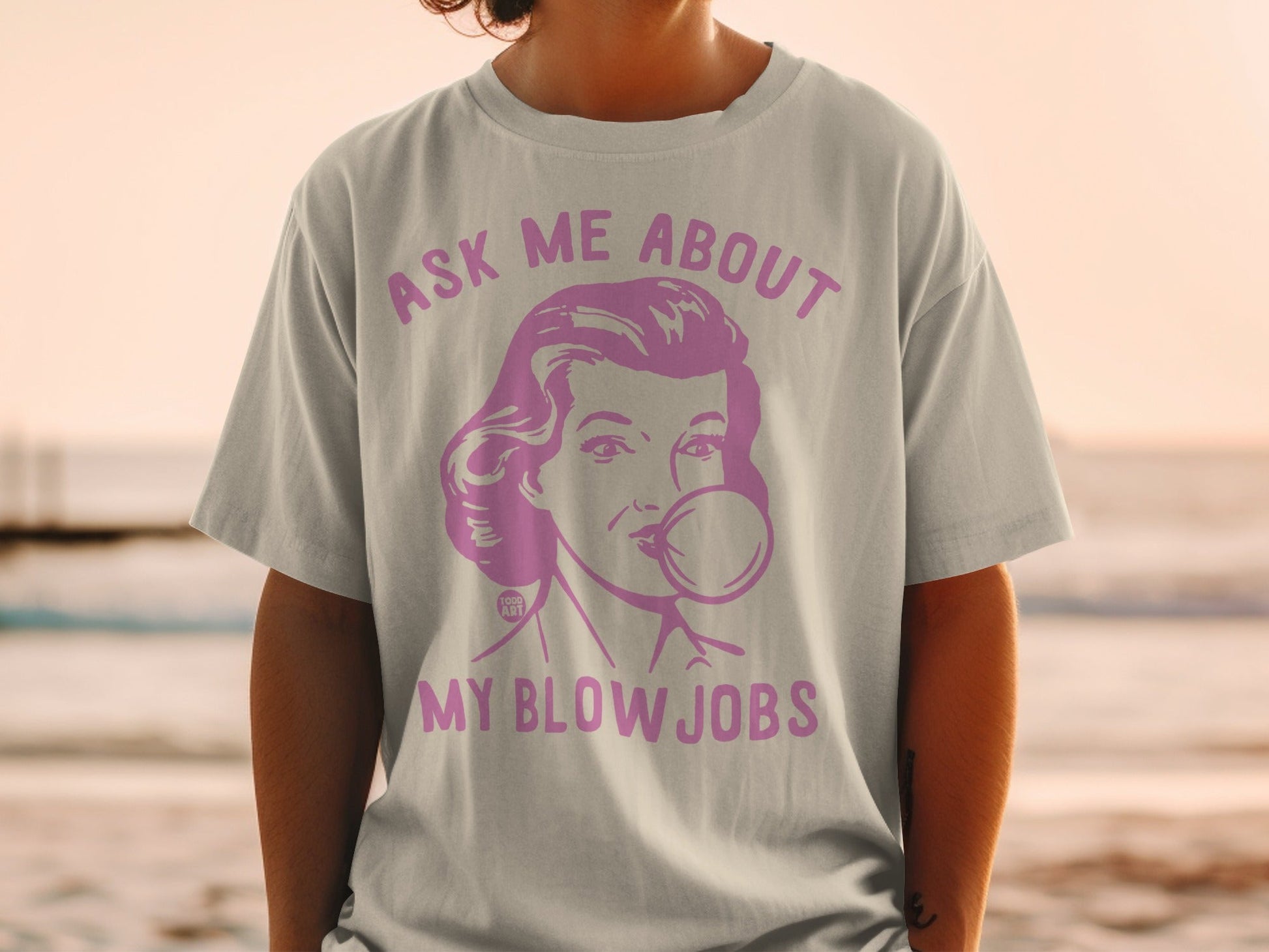 Pink graphic tee with retro woman blowing bubblegum and text.