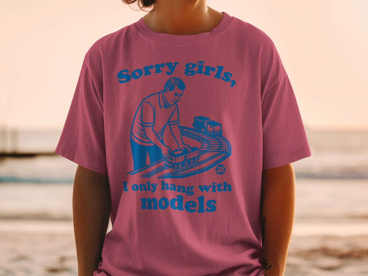 Pink t-shirt with blue text: "Sorry girls, I only hang with models" and toy train graphic.