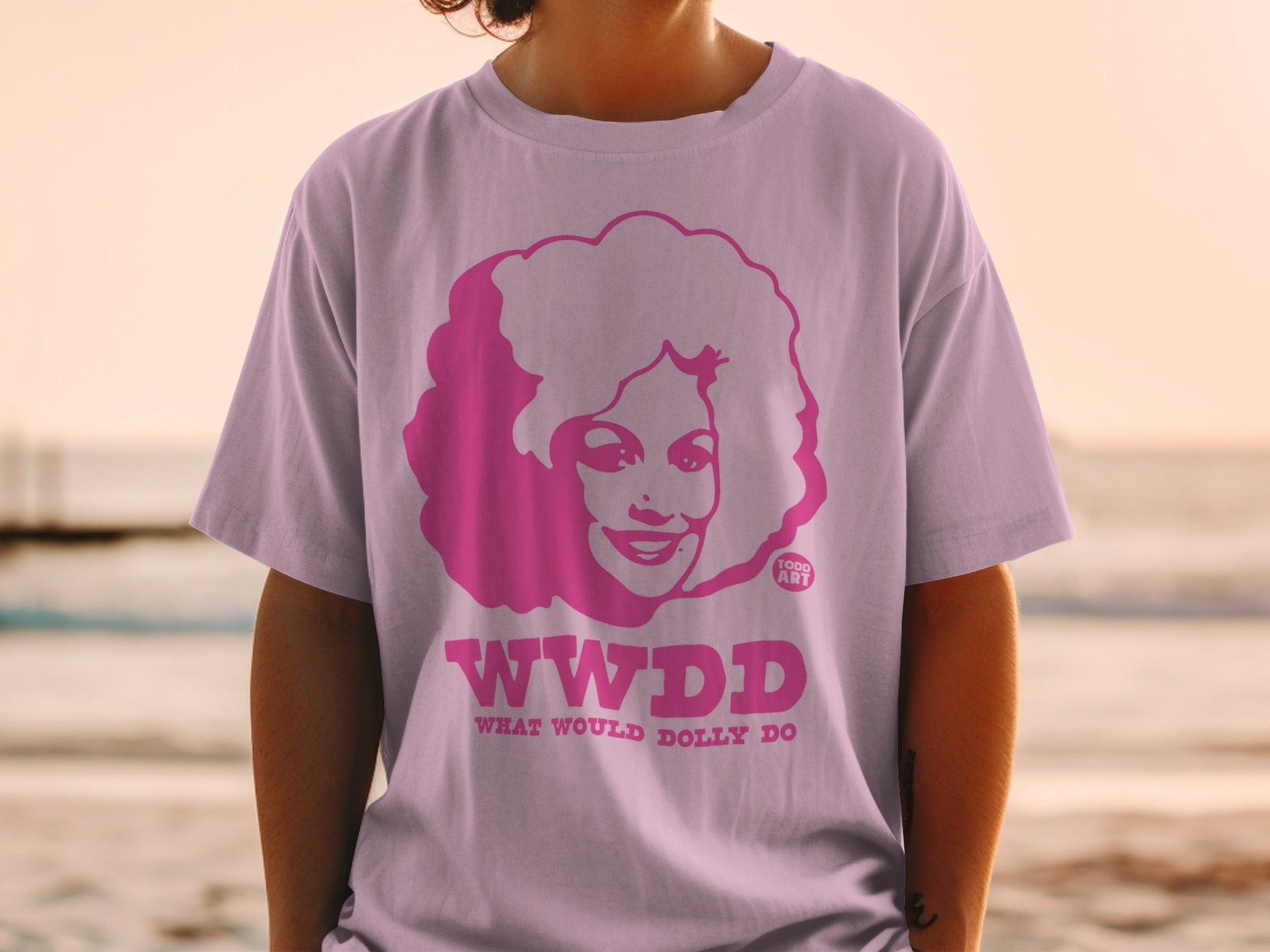 Pink t-shirt with "WWDD WHAT WOULD DOLLY DO" and Dolly Parton illustration.