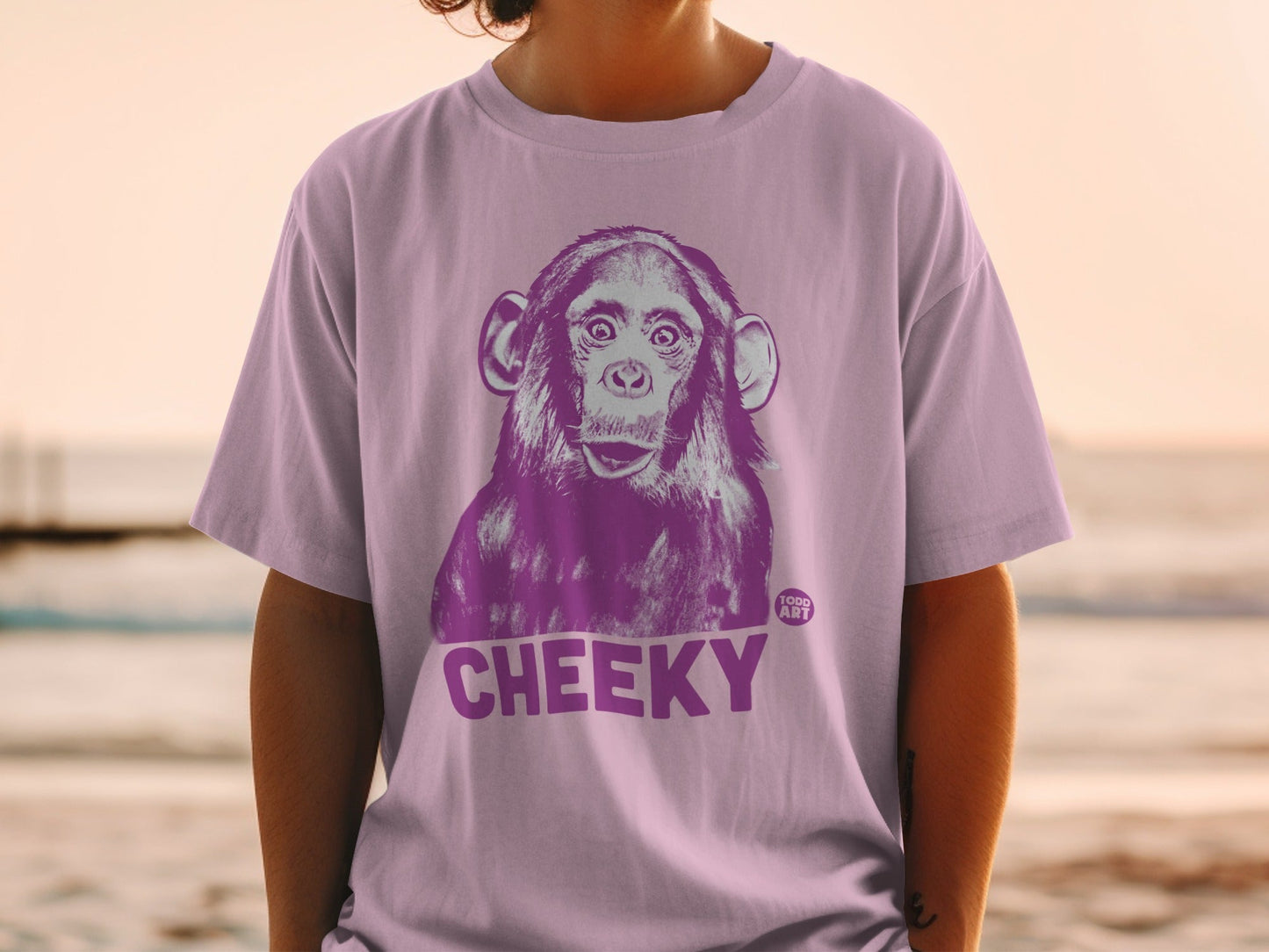 Purple t-shirt with a graphic of a surprised chimpanzee and the word "CHEEKY".