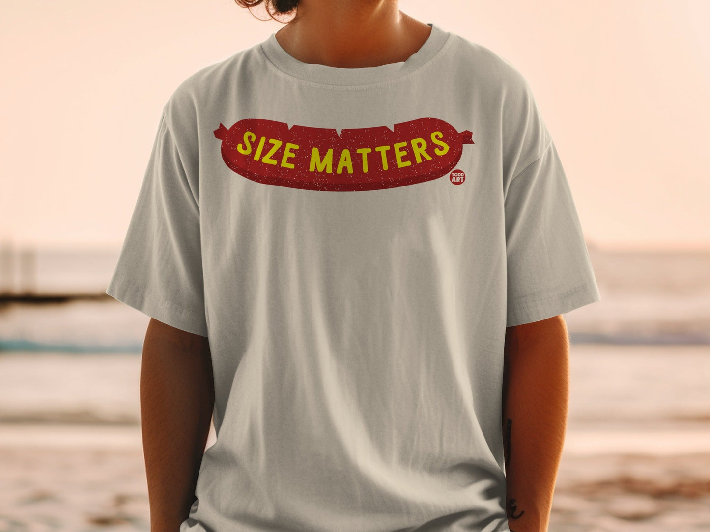 Light gray t-shirt with "SIZE MATTERS" text and a cartoon sausage graphic.