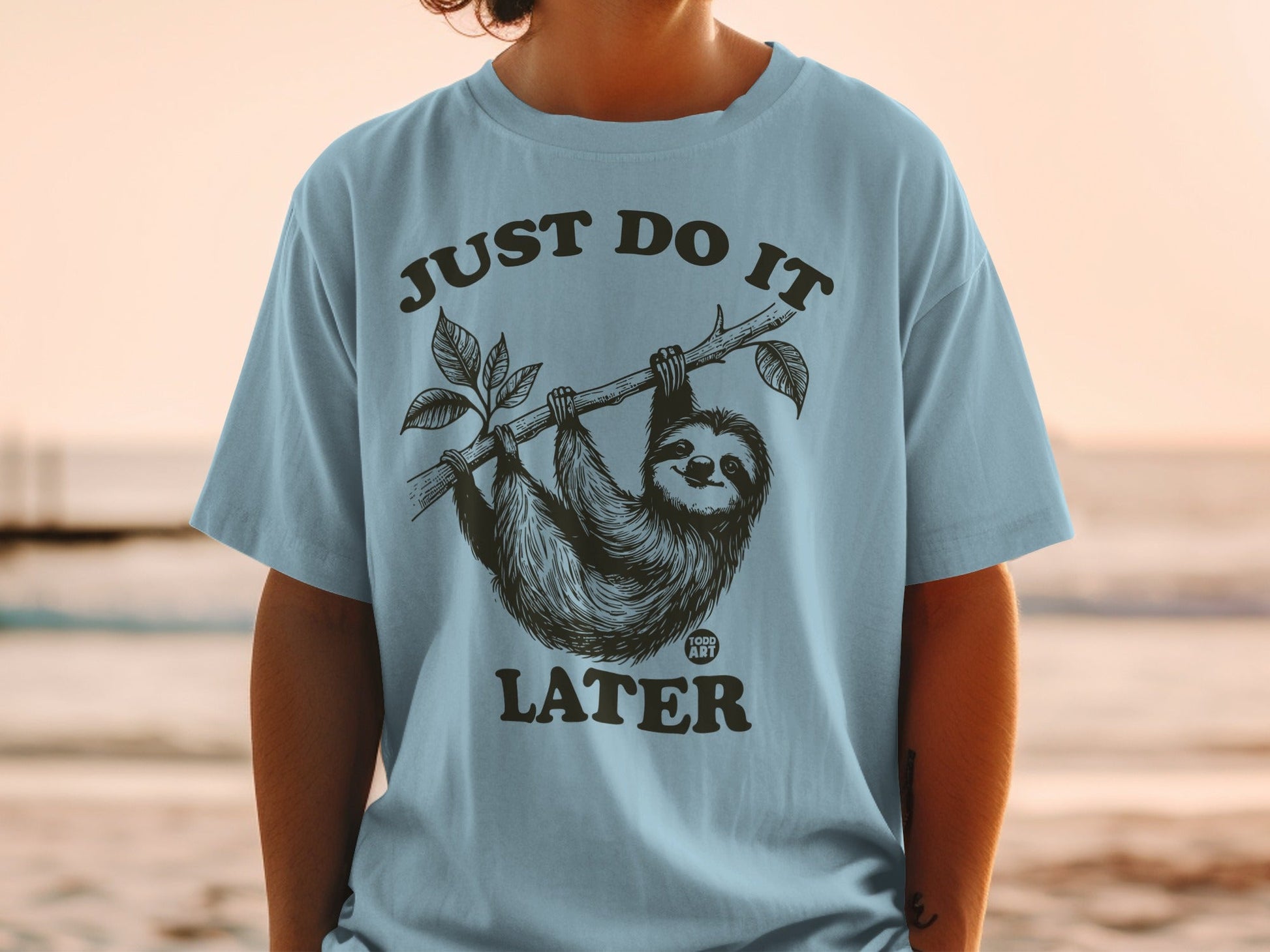 Sloth hanging from tree branch with text "JUST DO IT LATER".